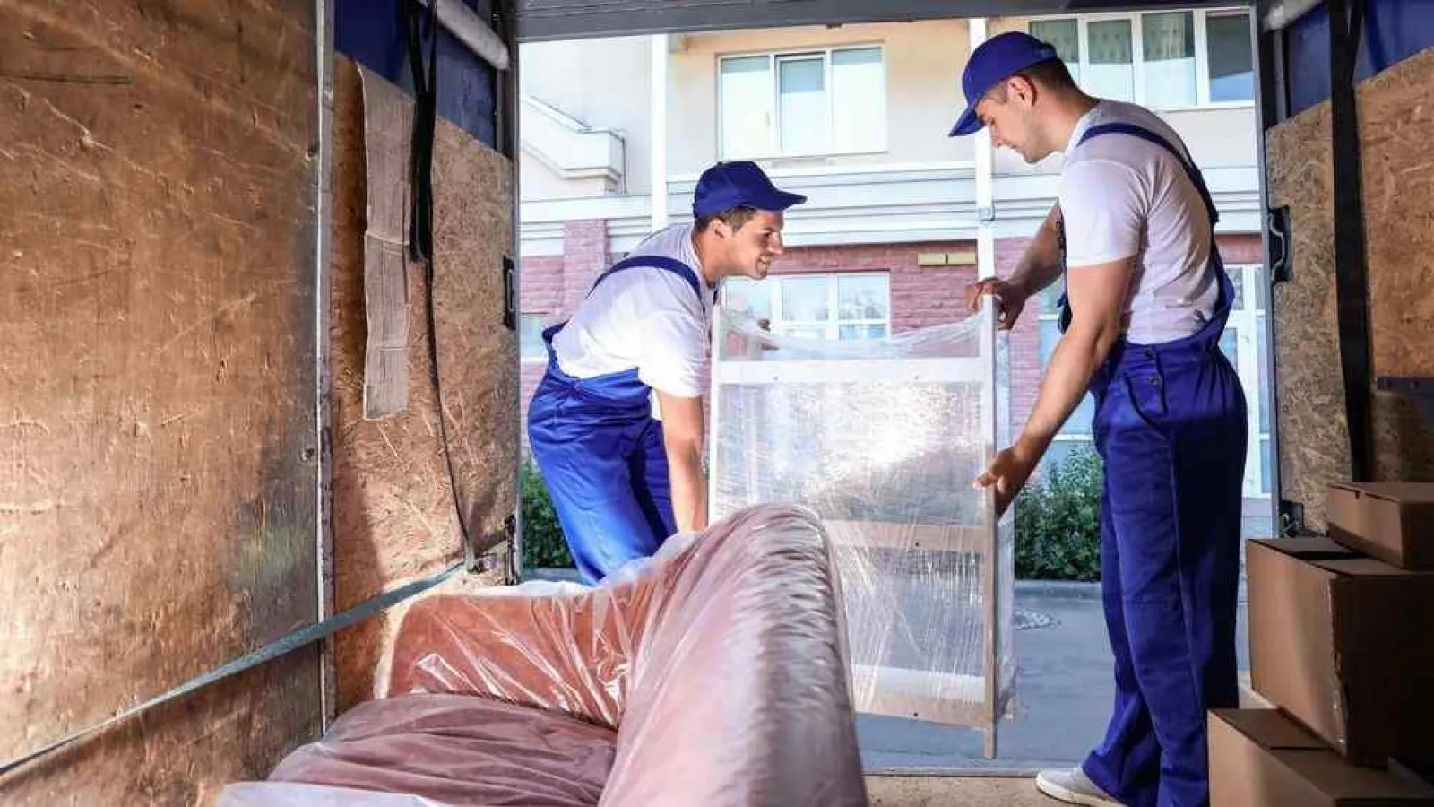 men in blue hats working on a building