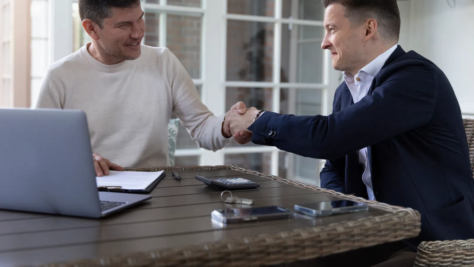 two men shaking hands over a service agreement