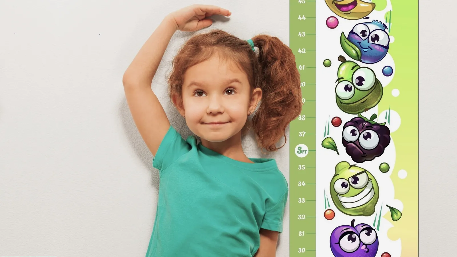 A young girl standing next to a printed Growth Chart