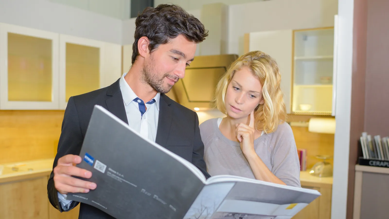 A man and a woman looking through a printed Catalog