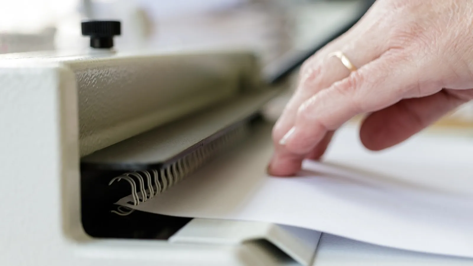 A person using a Wire-O Binding machine