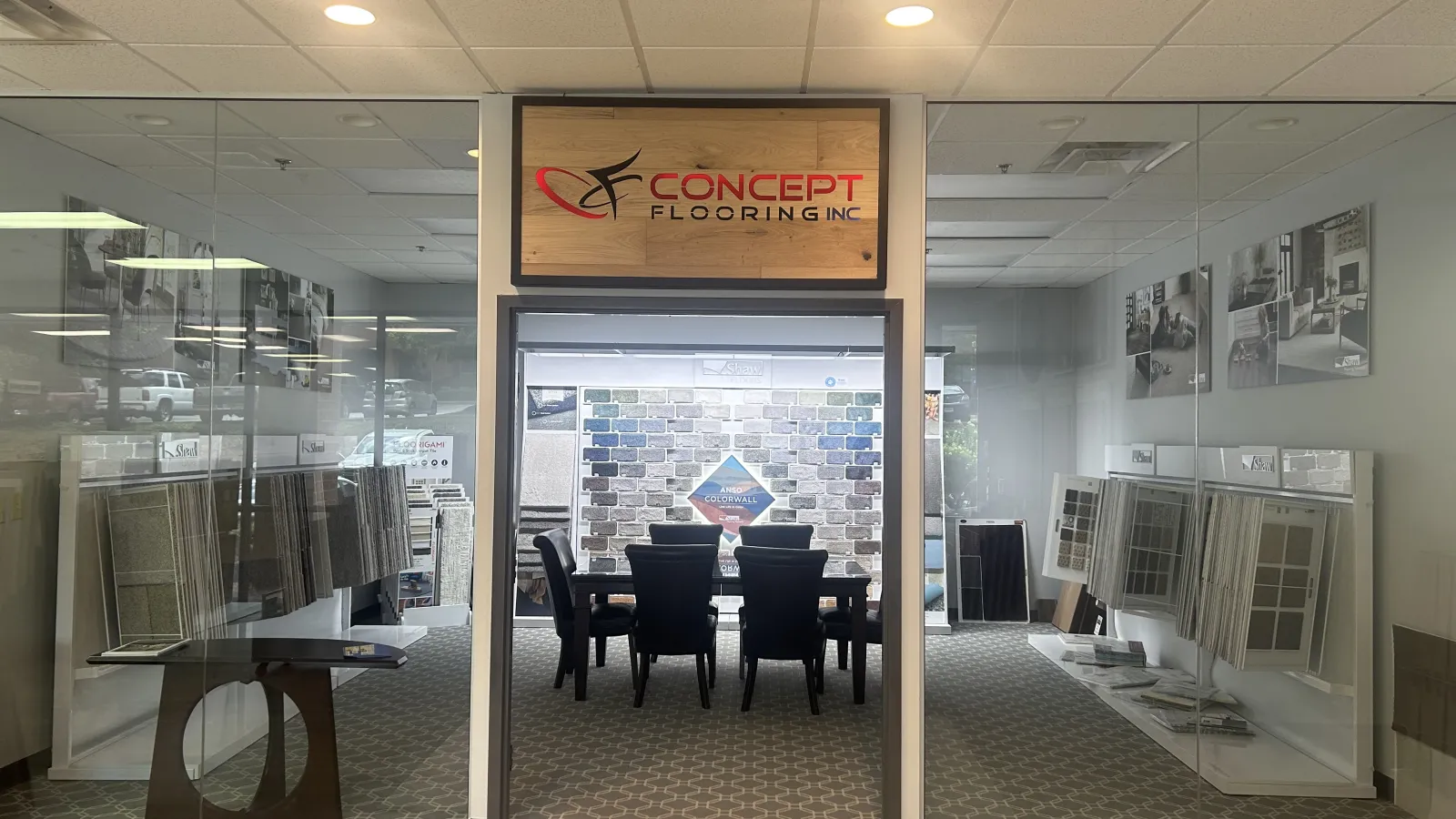 Concept Flooring showroom entrance with tile samples and a seating area for consultations inside