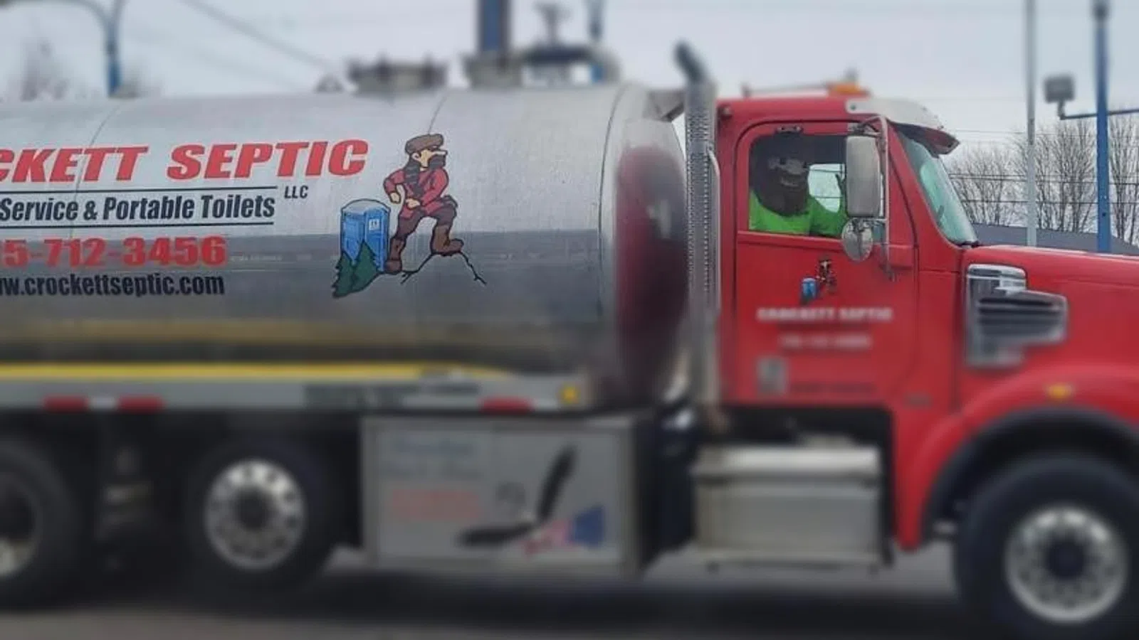 Crockett Septic truck parked with service information and graphic on the side.