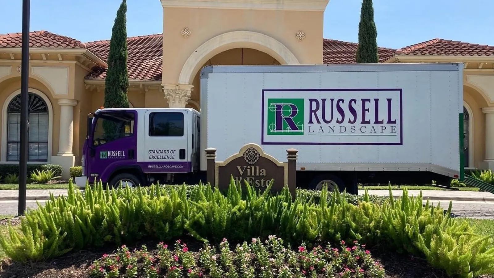 a Russell Landscape truck parked in front of a building with nice landscaping