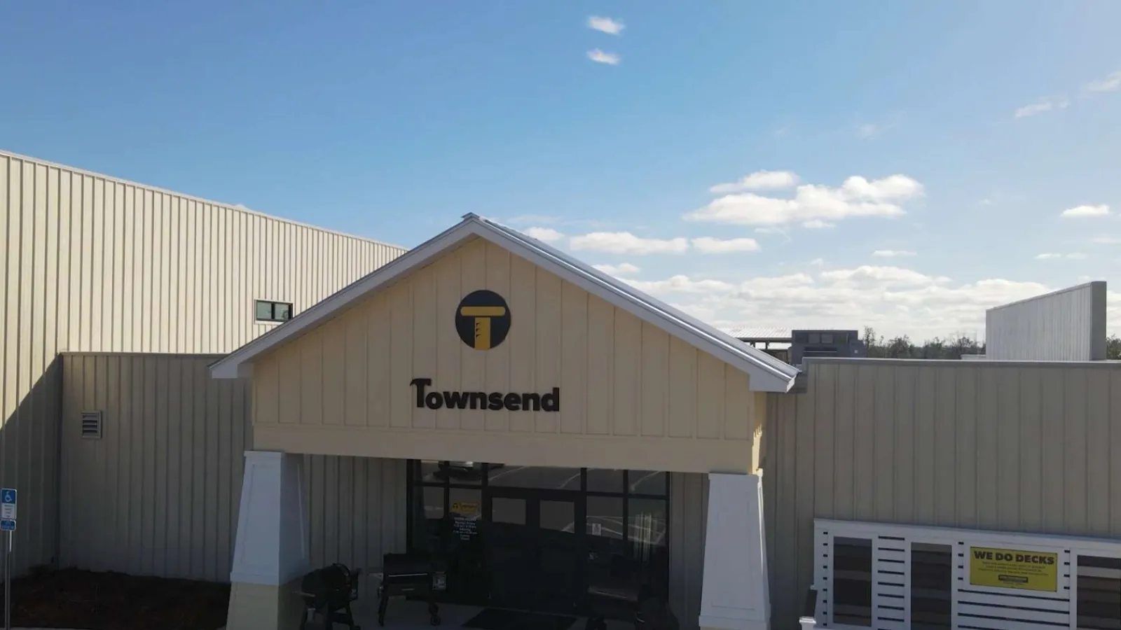 Townsend building entrance with logo under clear blue sky and visible signage on beige walls.