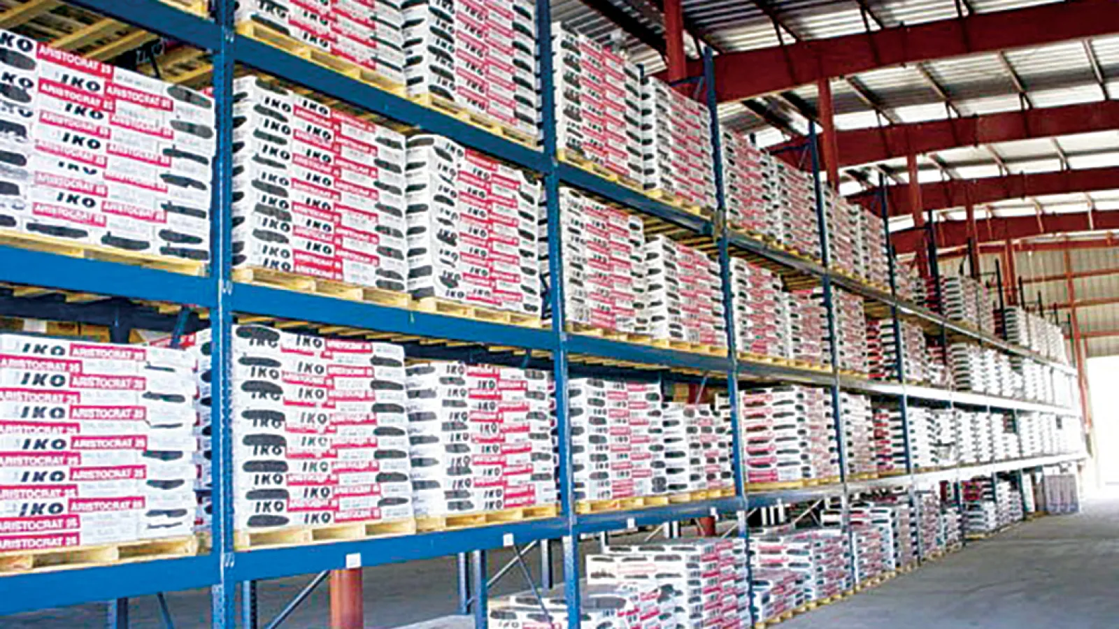 Warehouse shelves fully stocked with IKO branded bearing and industrial parts boxes.