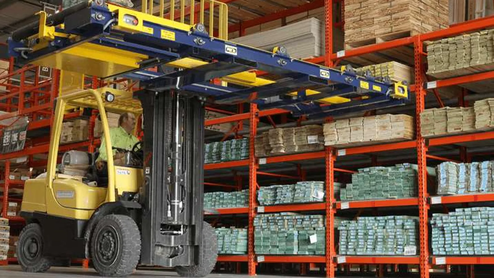 Warehouse forklift operator handling pallet racks filled with stacked boxes and packaged goods indoors