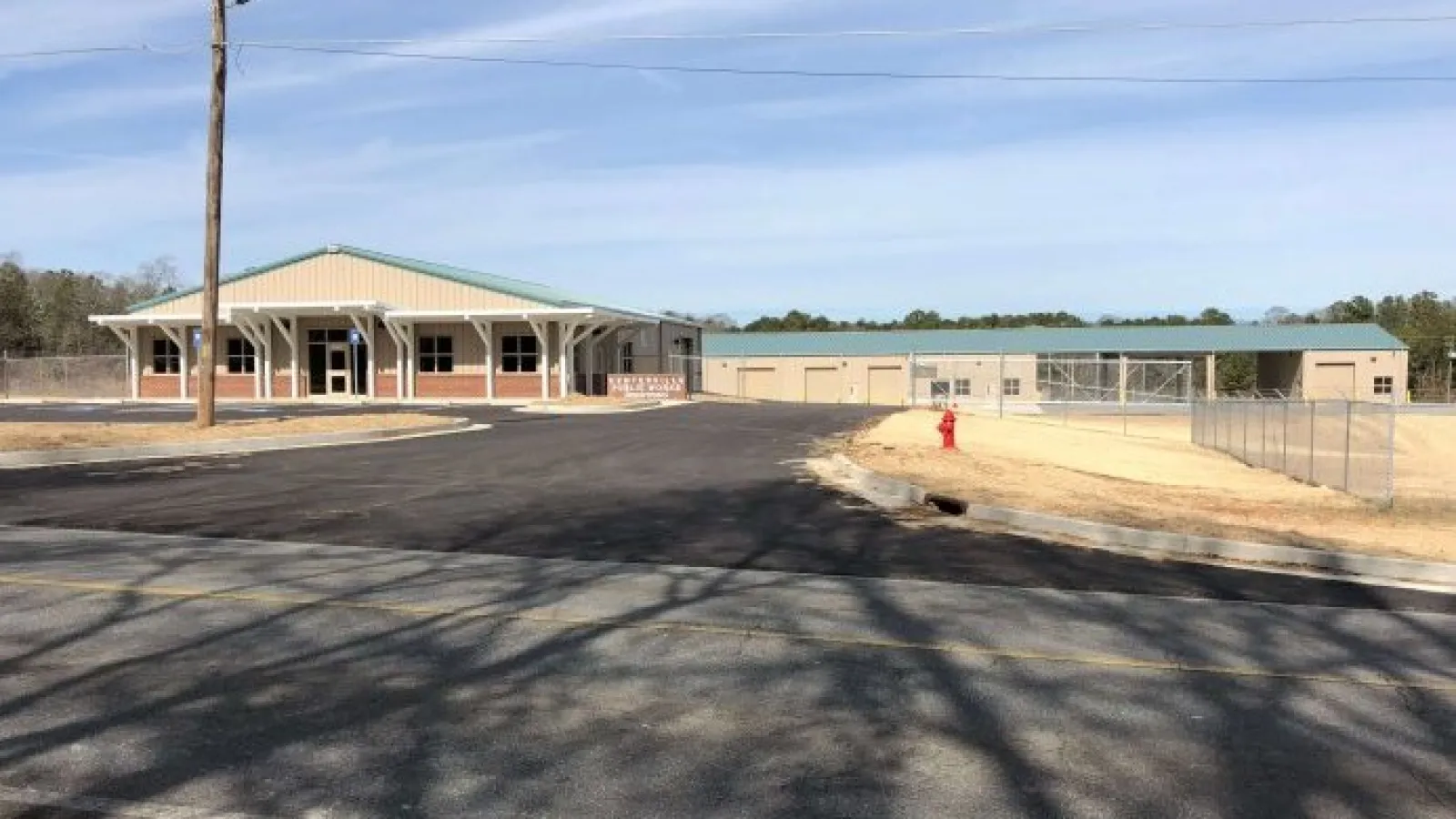 Newly constructed commercial buildings with green roofs and paved parking lot under clear sky