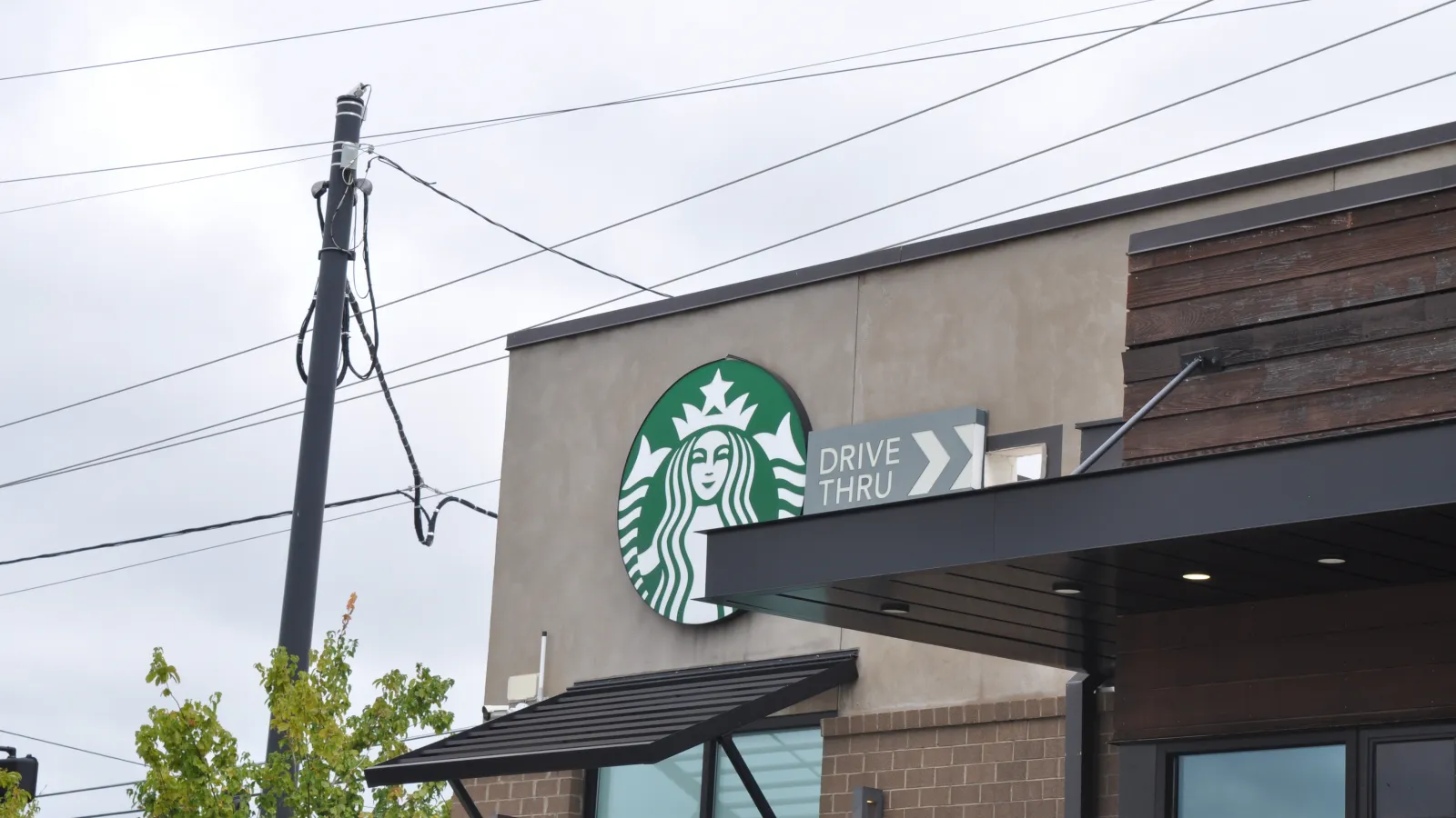 Starbucks coffee shop exterior with drive-thru sign on a cloudy day