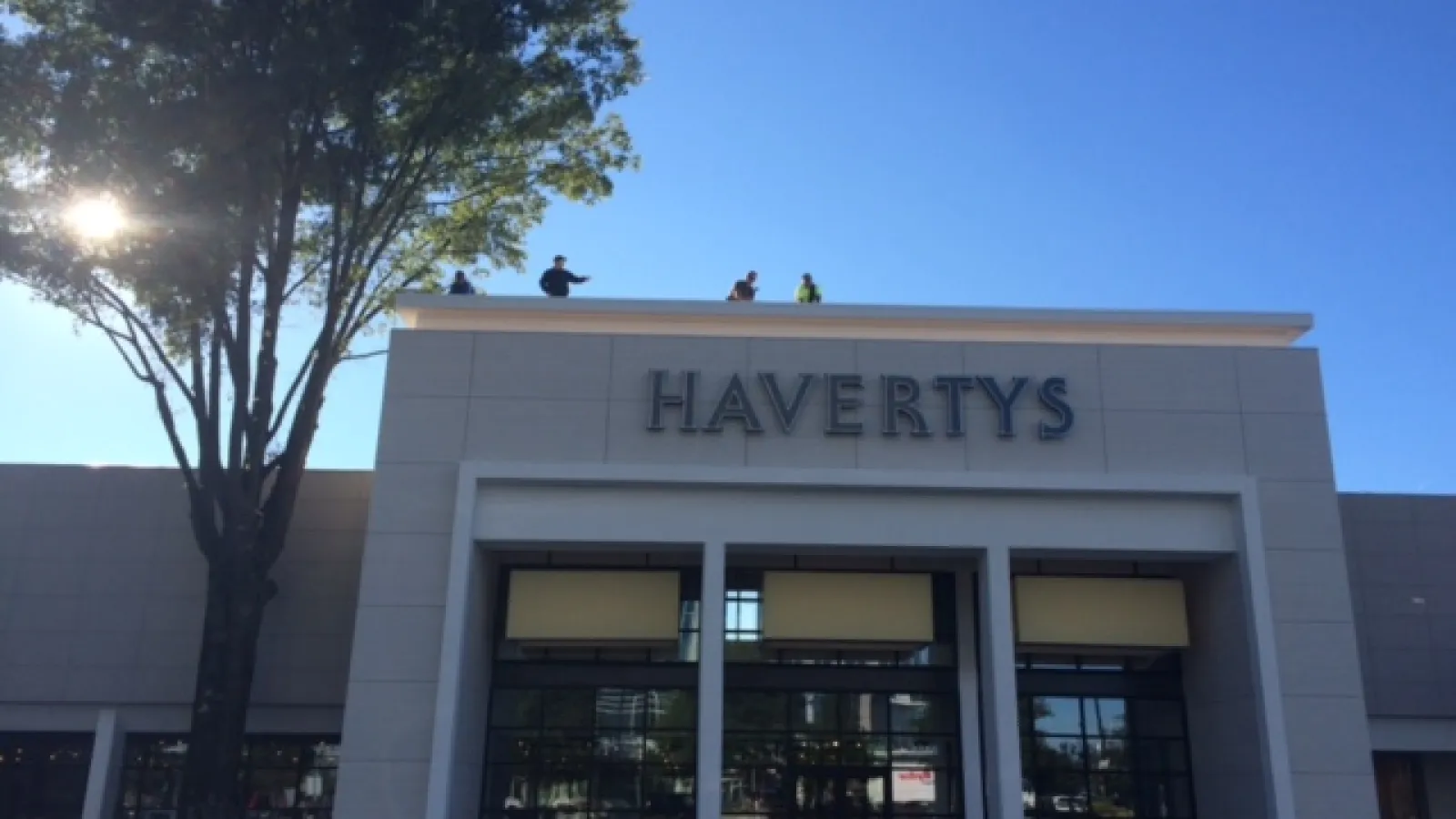 Havertys furniture store exterior with clear blue sky and large tree on the left side.