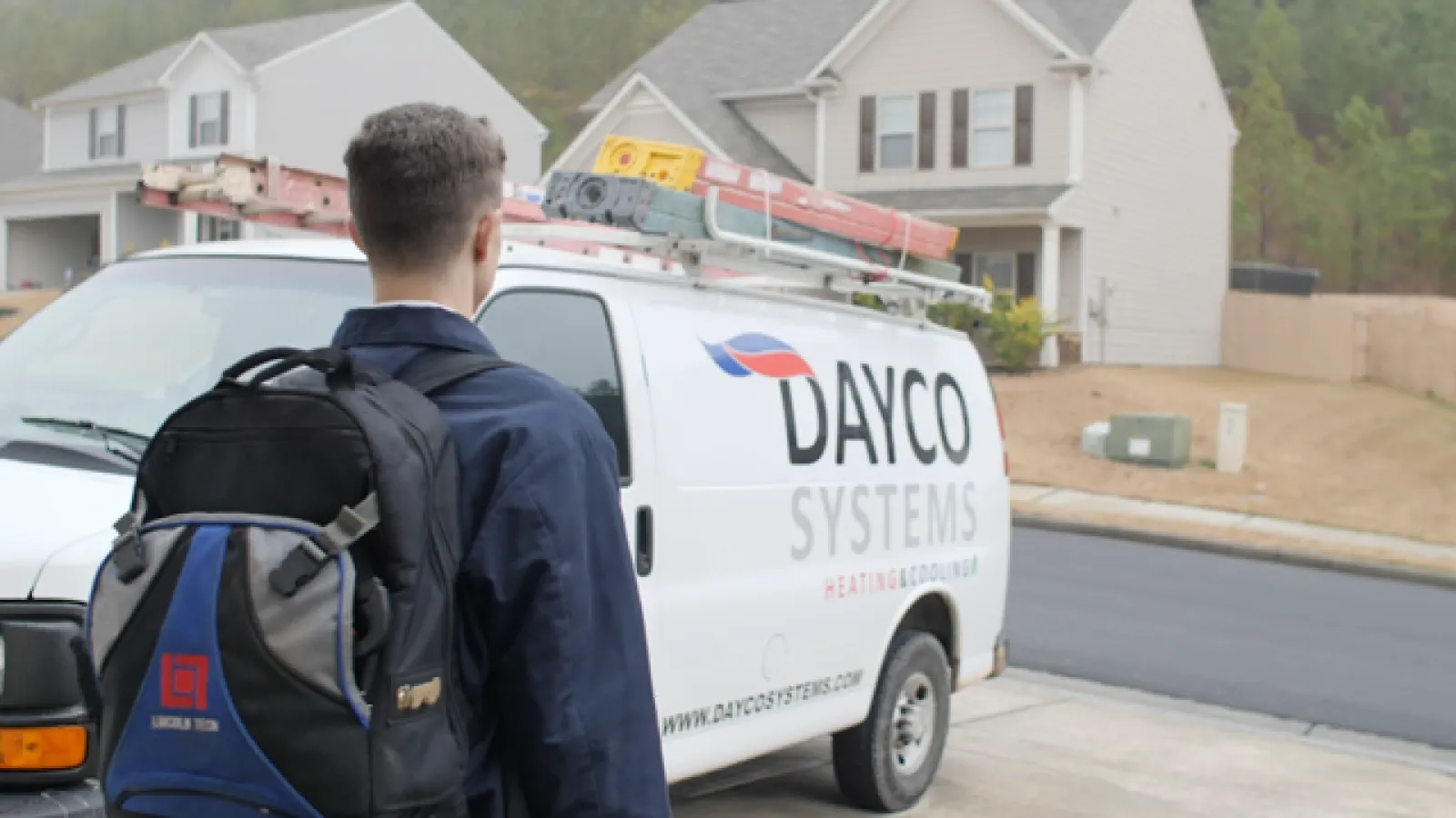 a man with a backpack looking at a white van