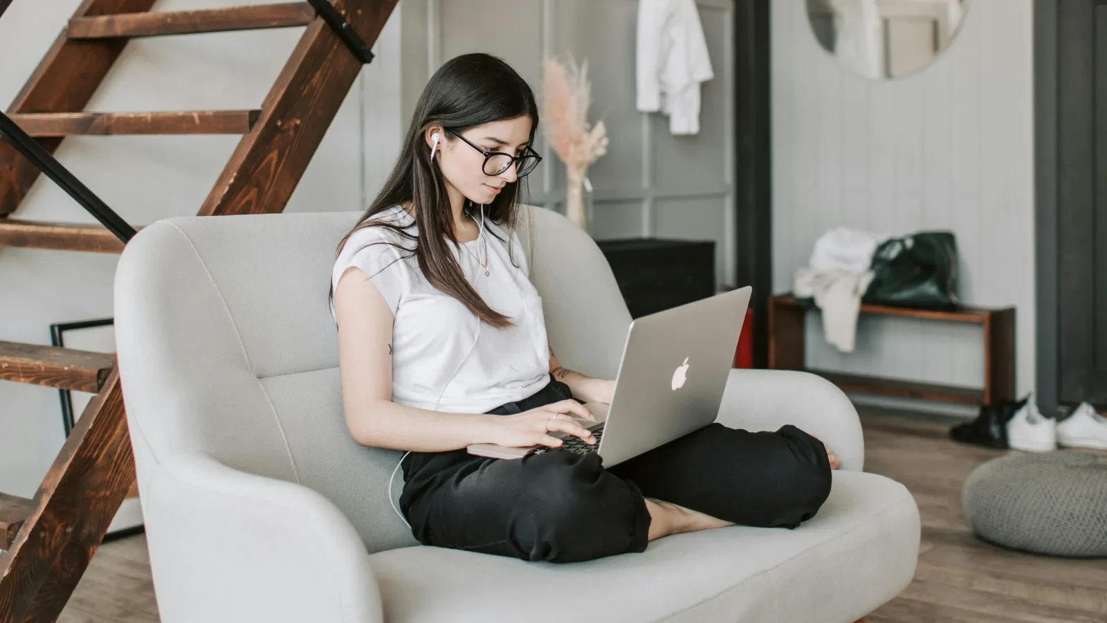 a person sitting on a white chair with a laptop