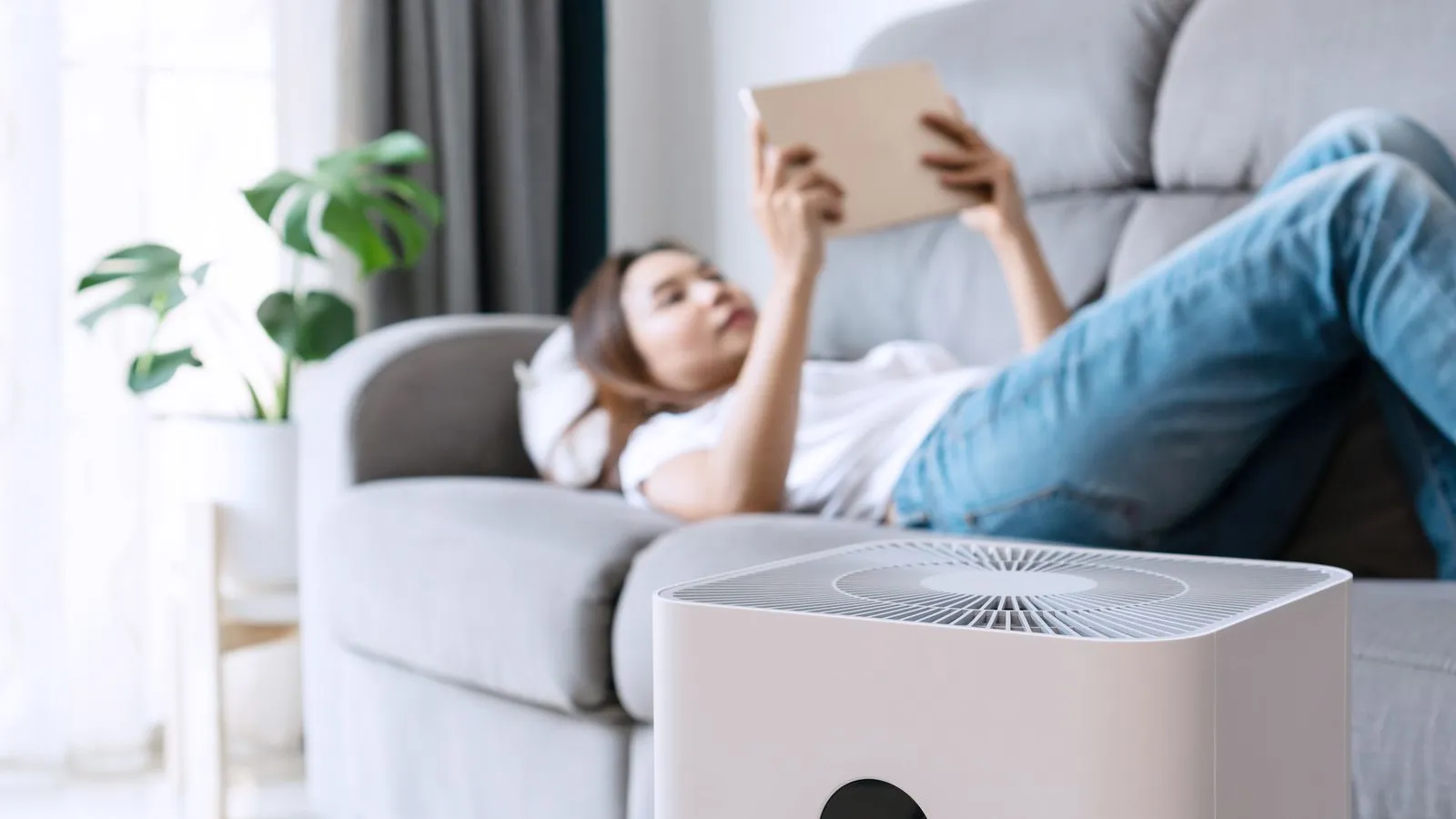 a person lying on a couch reading a book