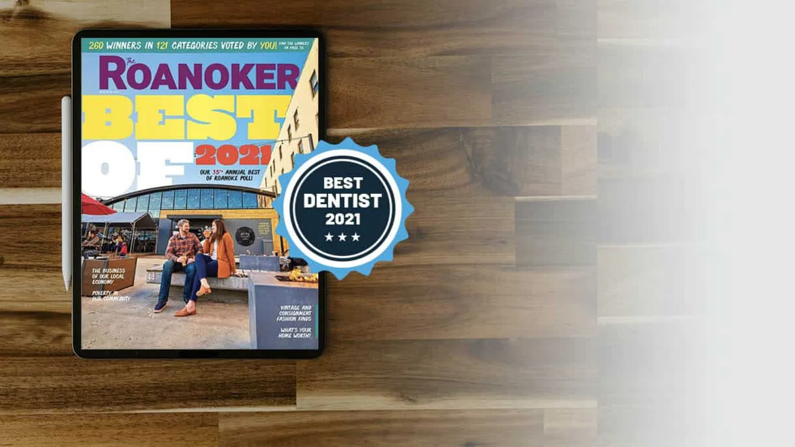 Tablet displaying Roanoker Best of 2021 magazine cover with Best Dentist 2021 badge on wooden table.
