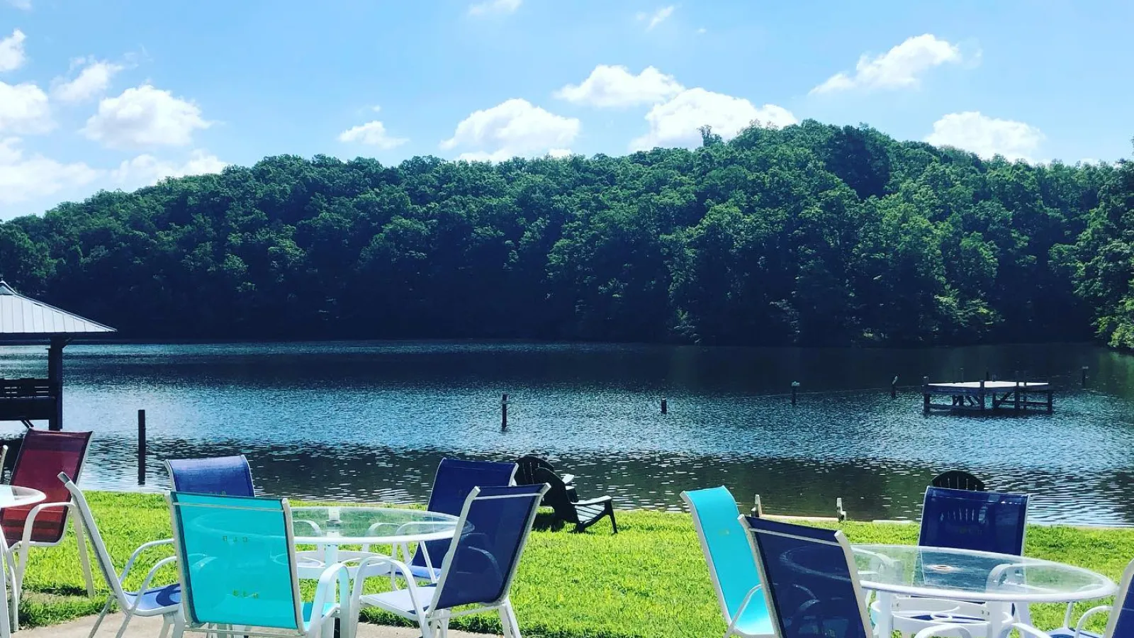 a group of chairs and tables by a body of water