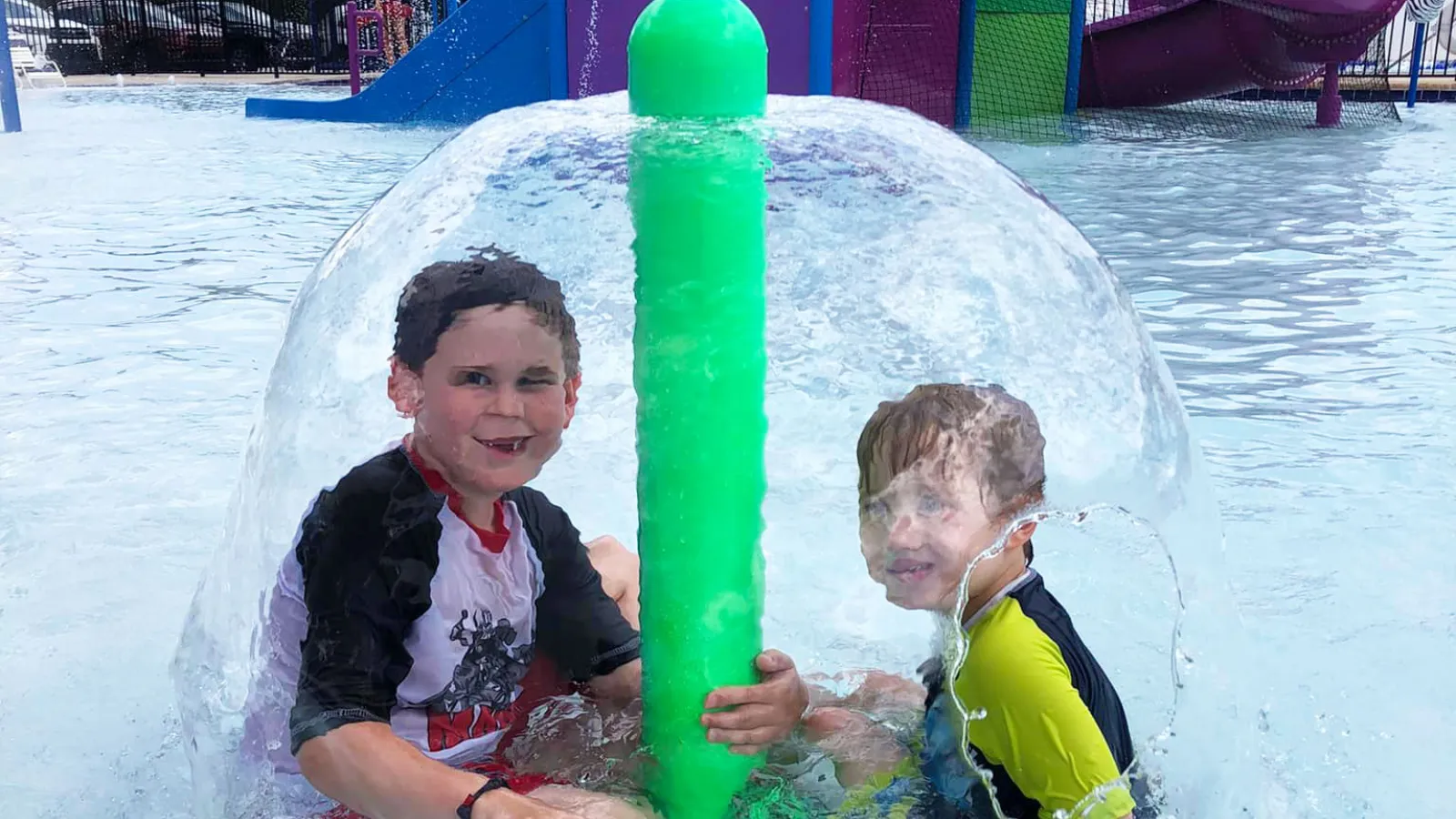 a person and a boy in a water slide at a water park