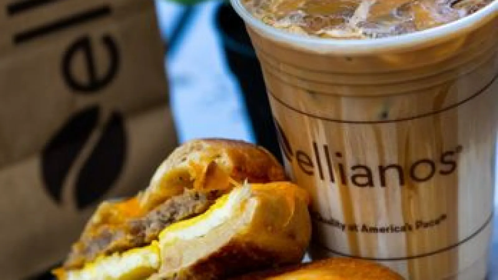 a cup of coffee next to a pastry and a jar of spread