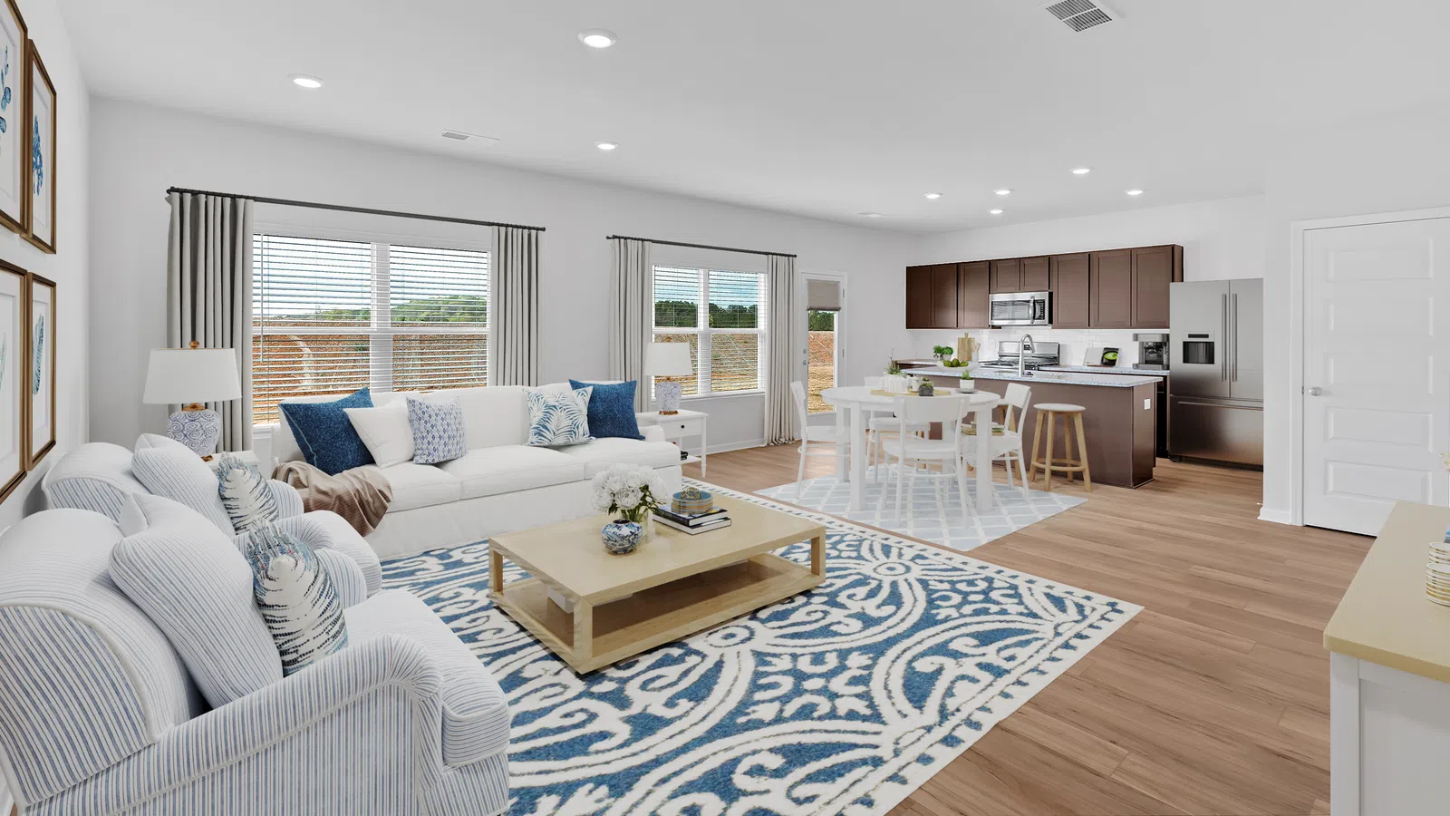 Bright modern living room with cozy furniture and elegant decor, featuring a stylish rug and open kitchen area.