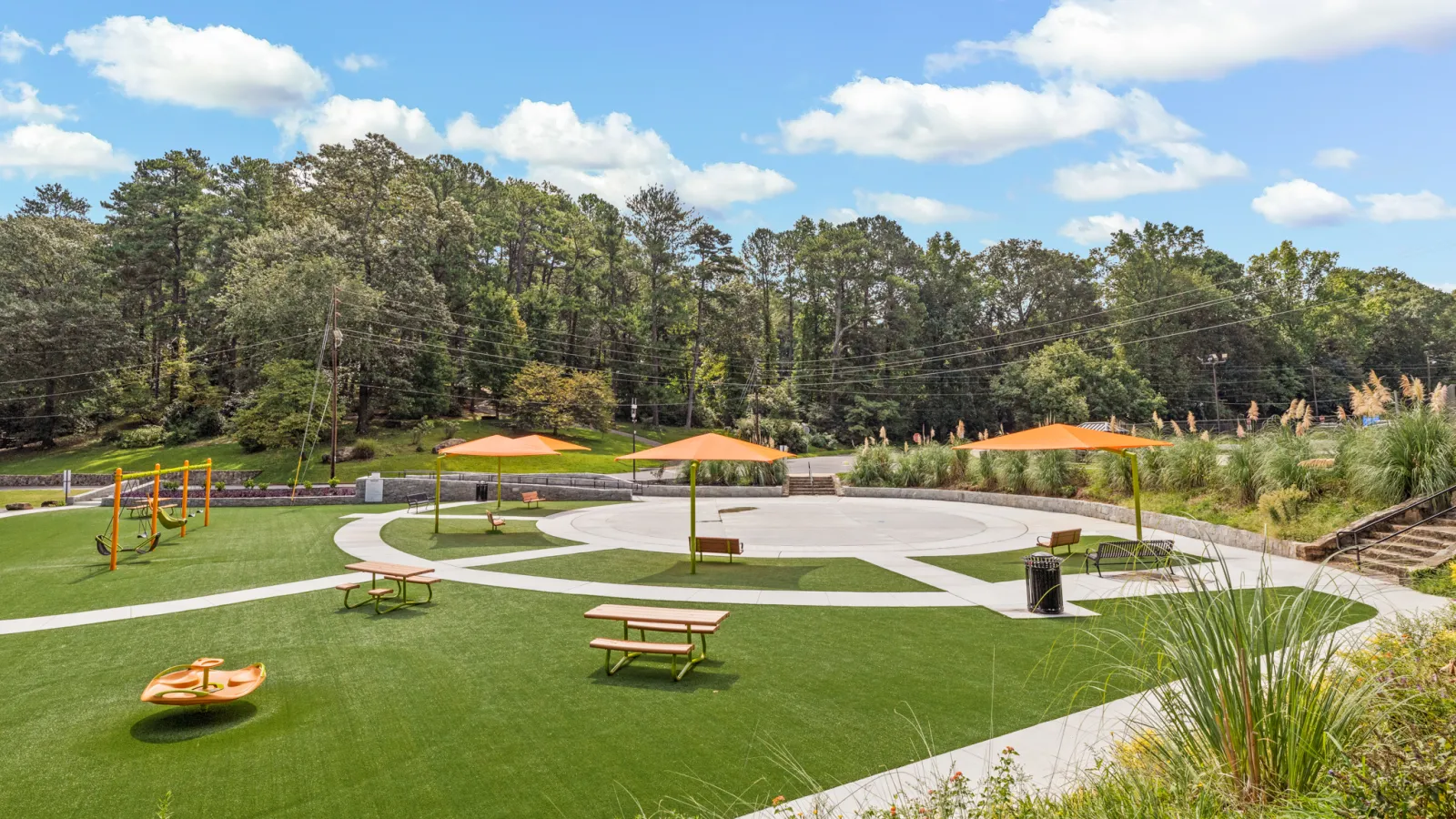 a park with benches and umbrellas