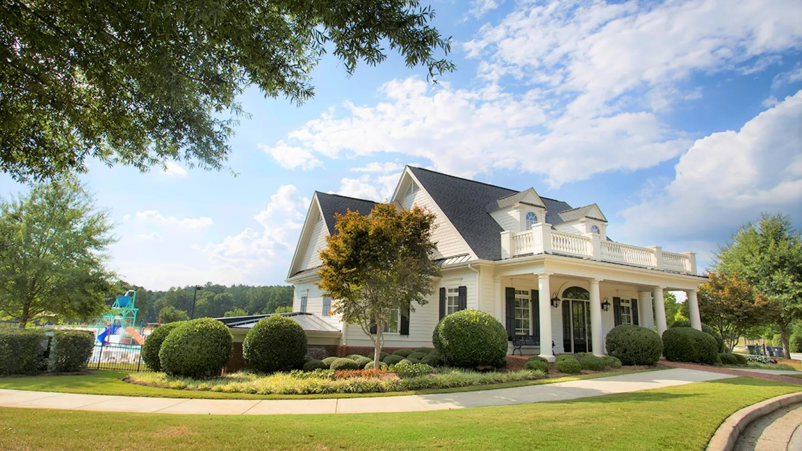 a large house with a lawn and trees in front of it