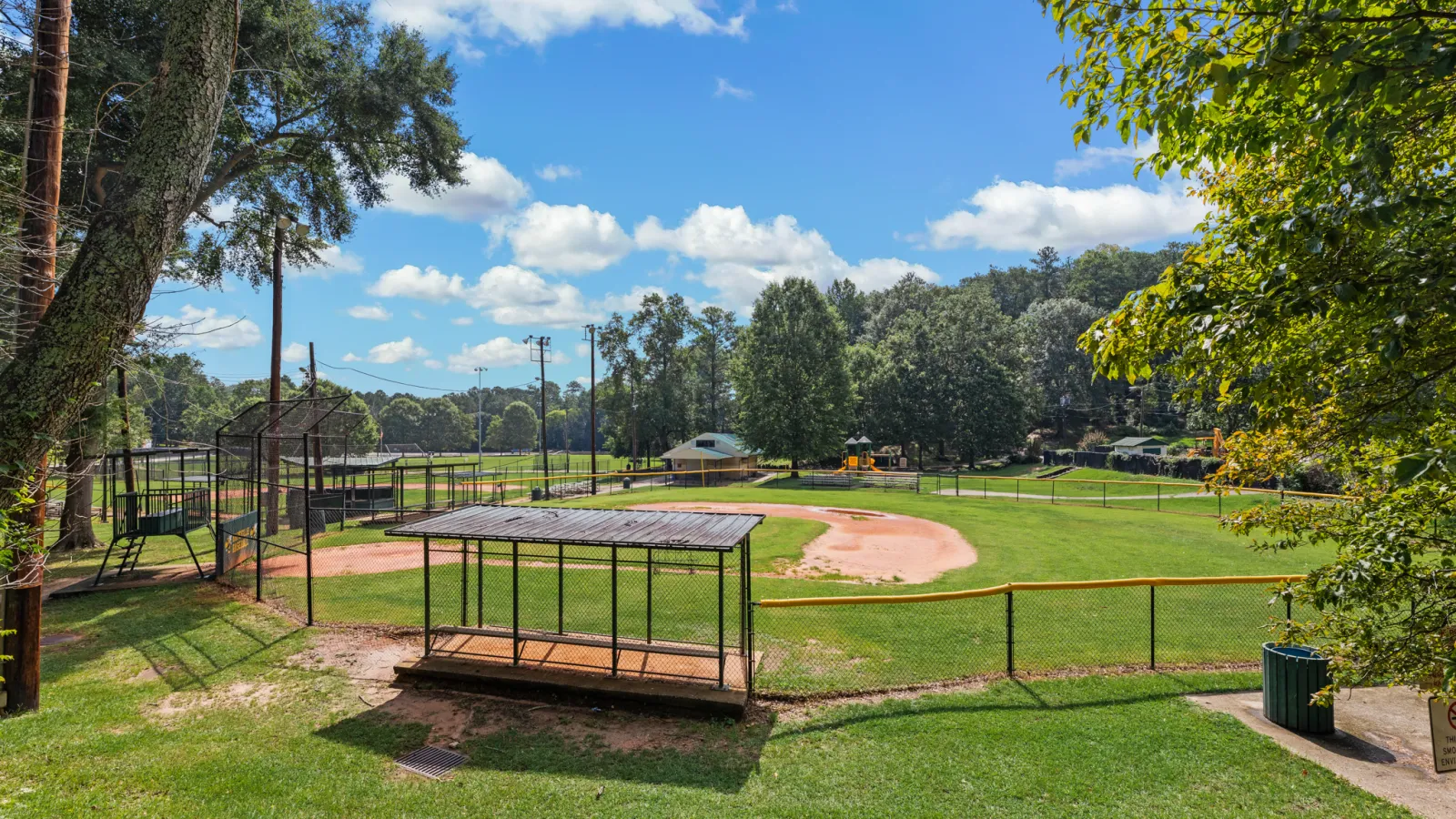 a small playground with a trampoline and trees