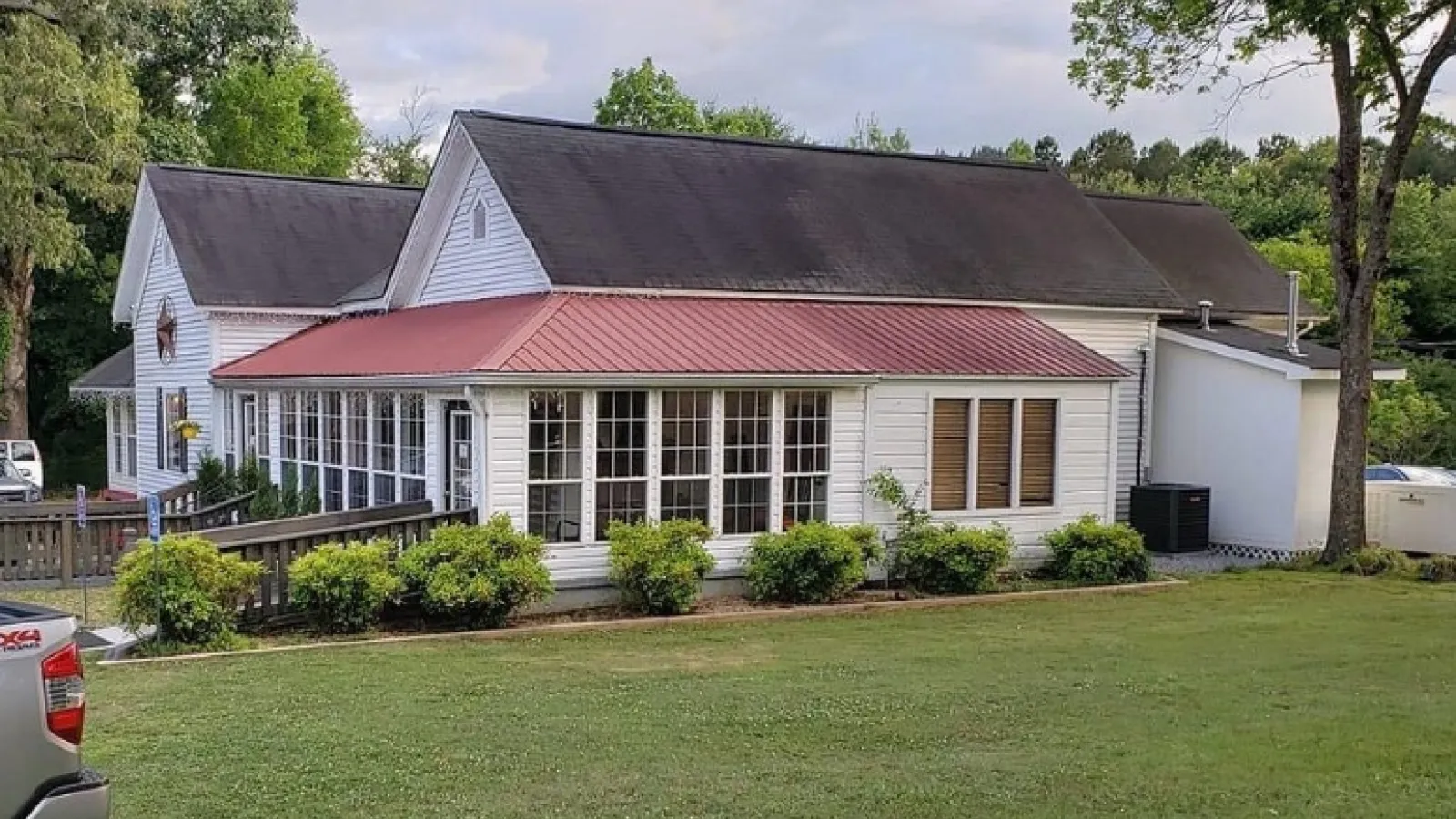 a house with a red roof with Mission House in the background
