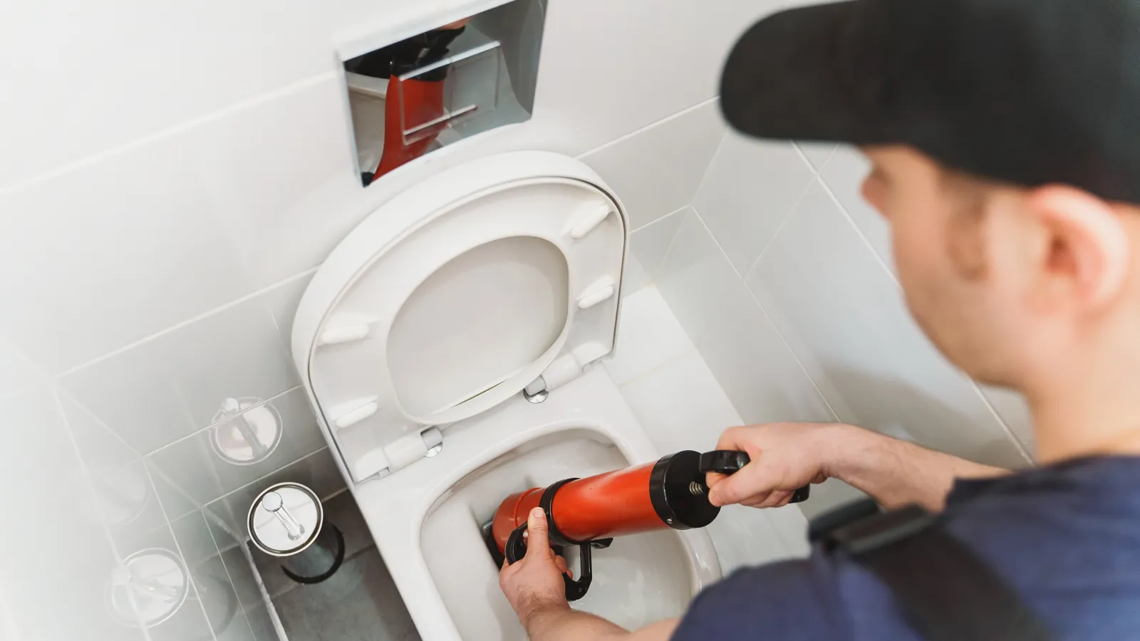 a person pouring a bottle of wine into a toilet