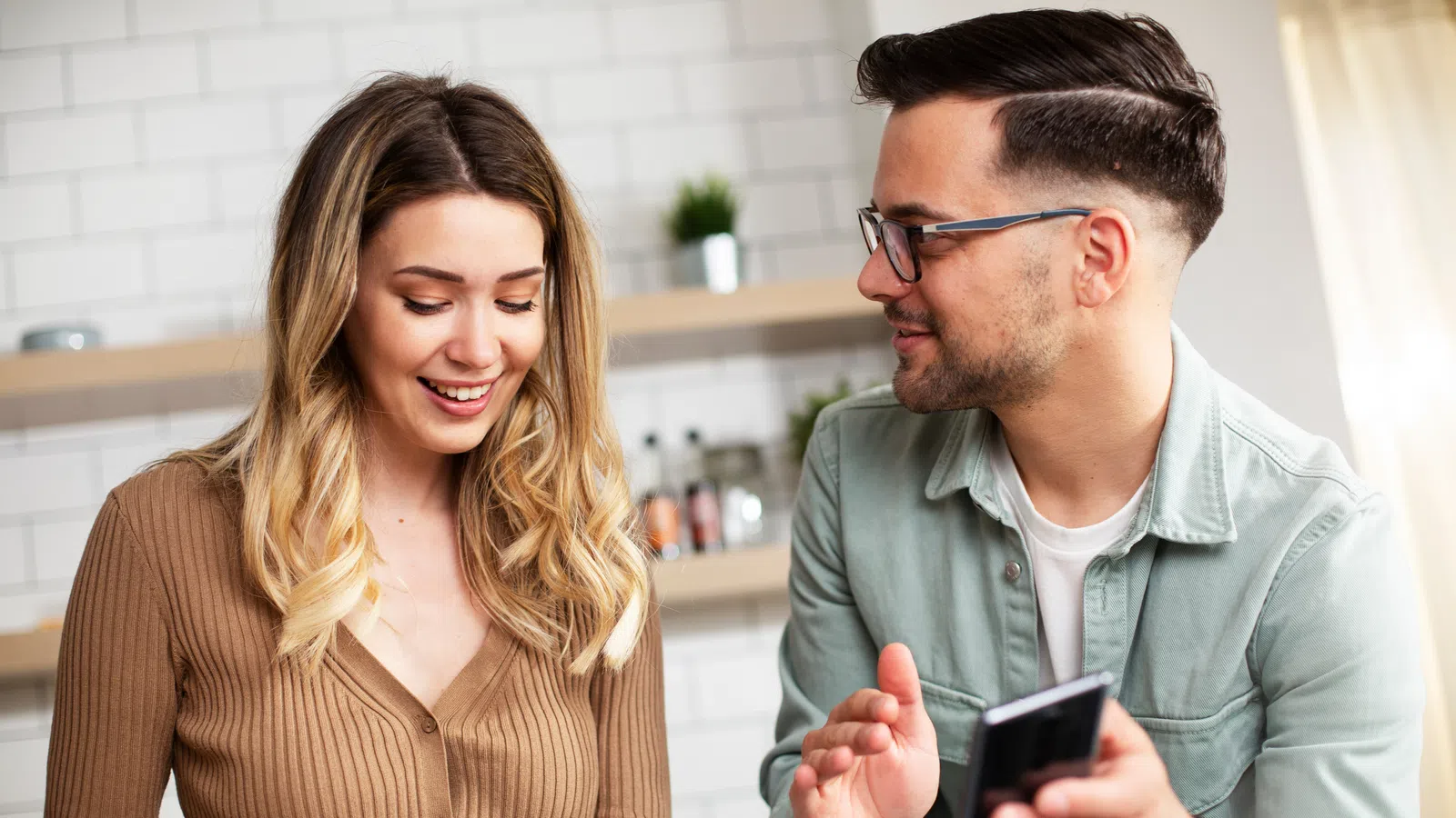 a man and a woman looking at a cell phone