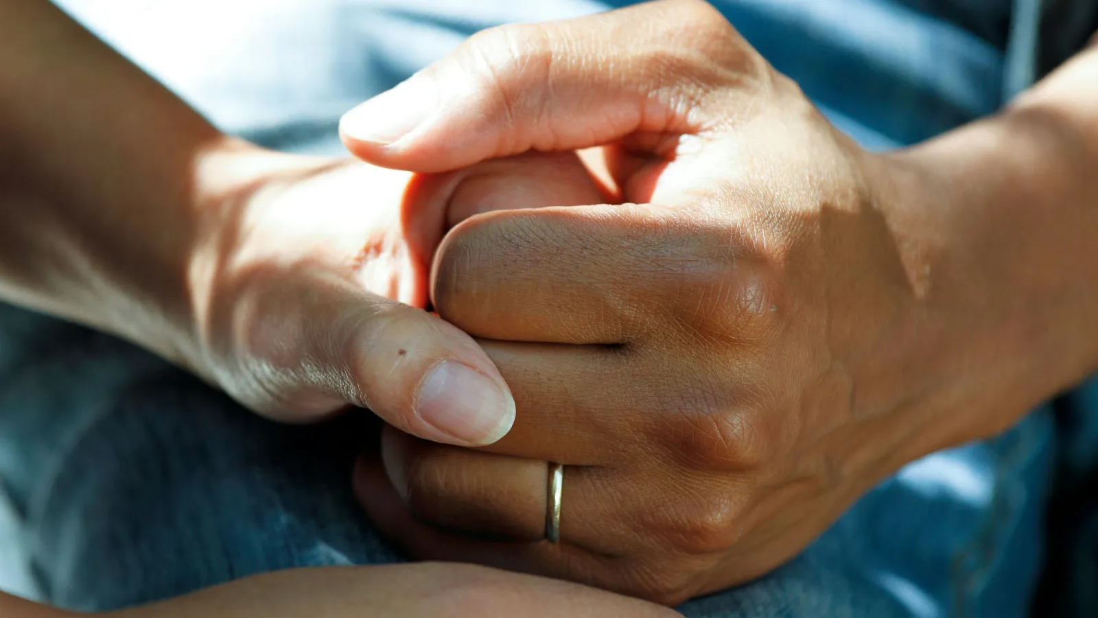 Two hands clasped together in a gesture of support and comfort, showcasing unity and connection.