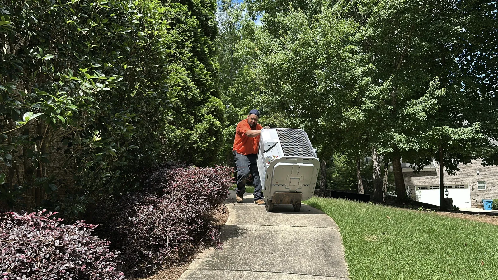 Estes Technician in a orange uniform Installing a Heat Pump thanks to the Georgia HEAR Programs Rebate