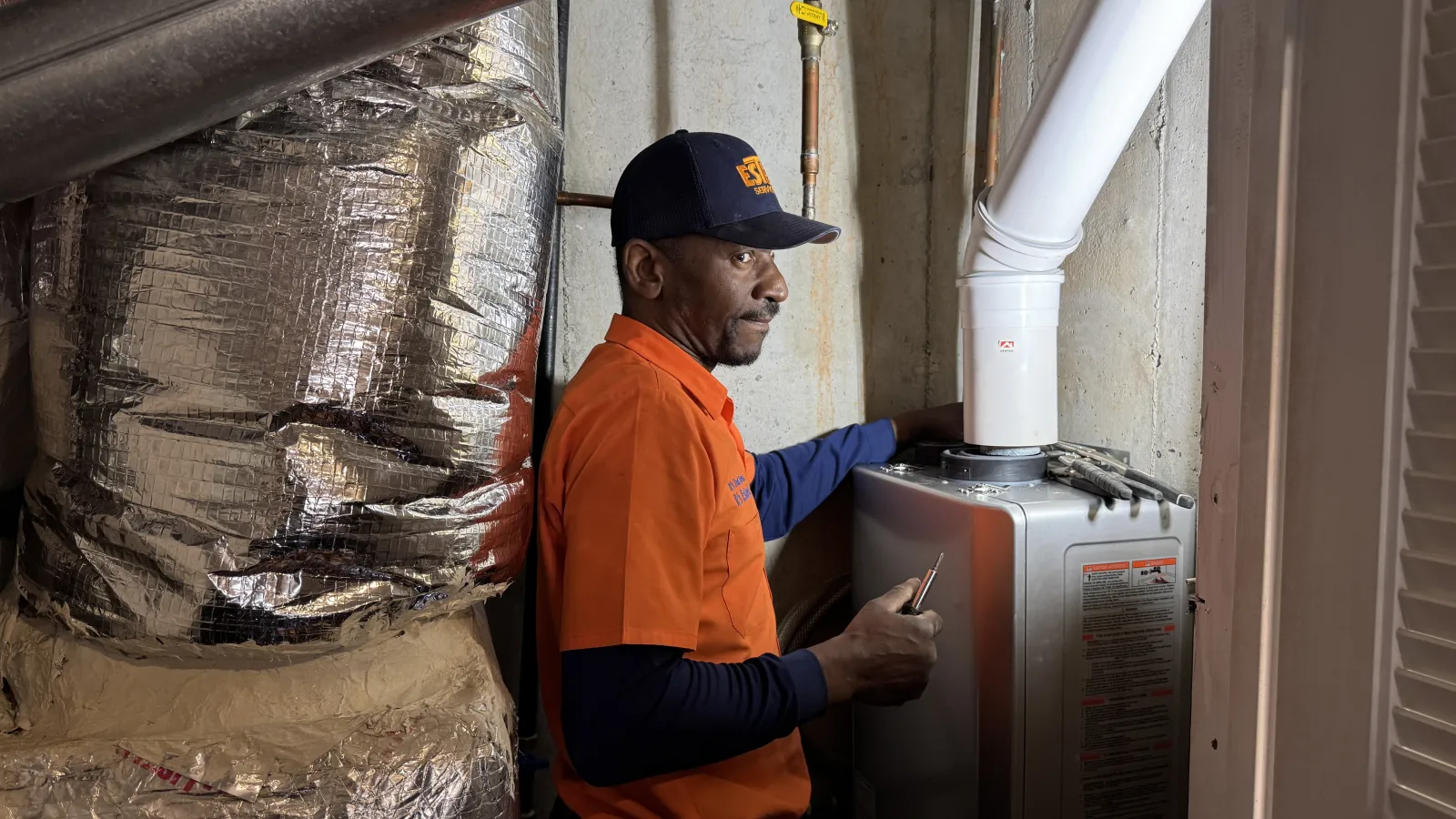 Estes Plumber installing a tank less water heater.