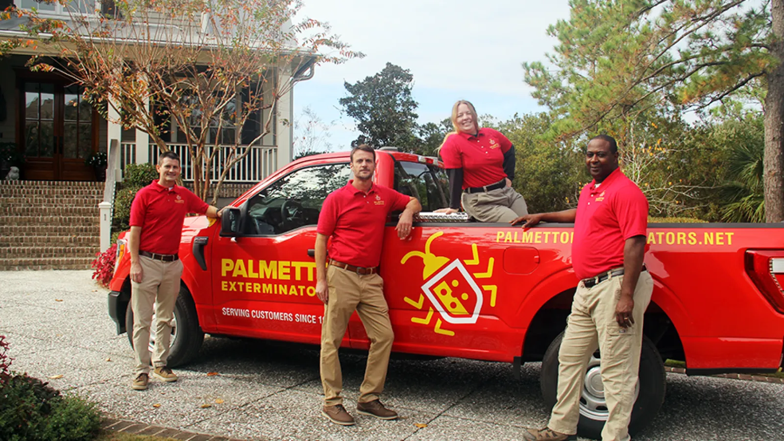 a group of people standing next to a red truck