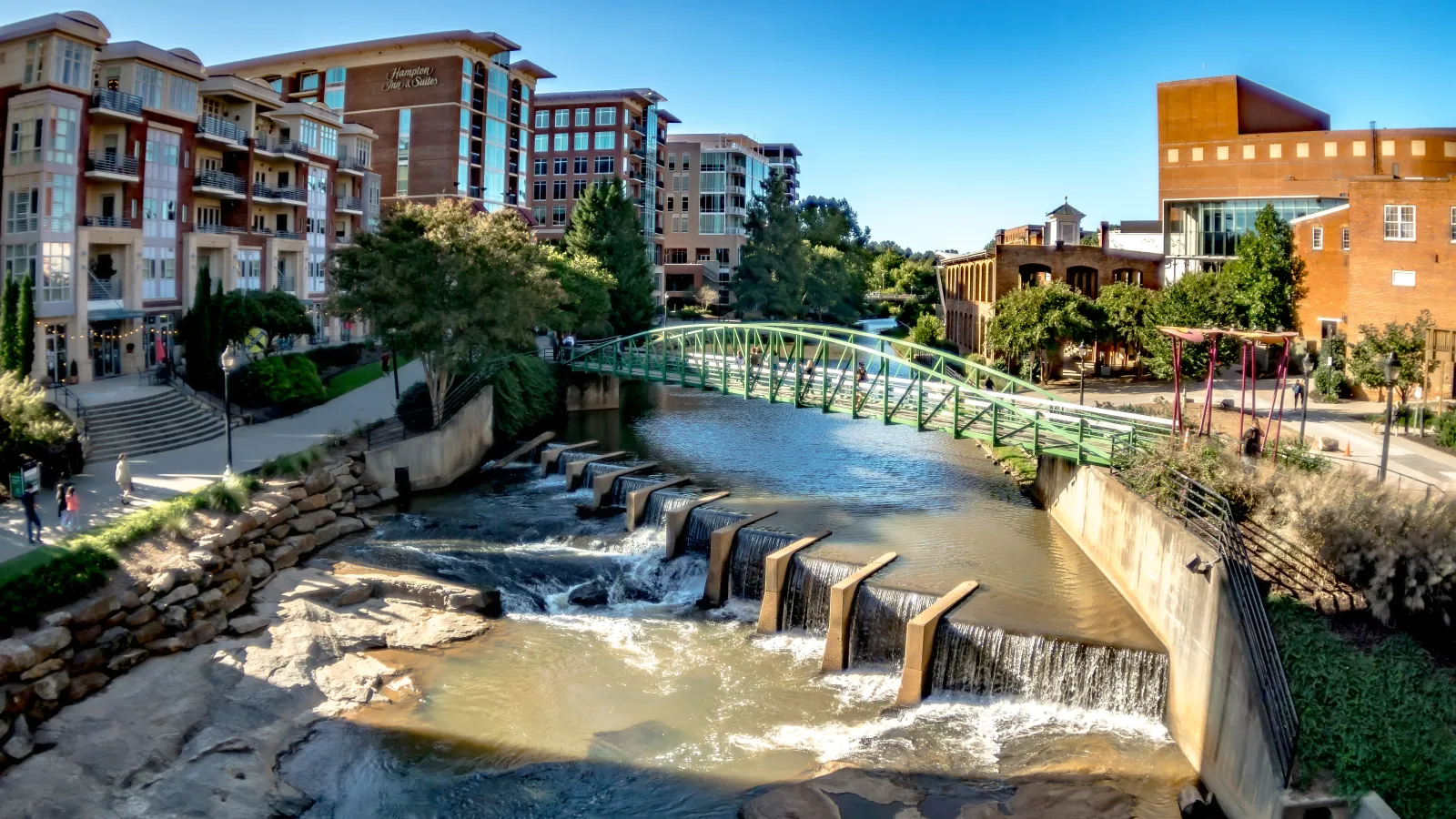 a bridge over a river with buildings in the background