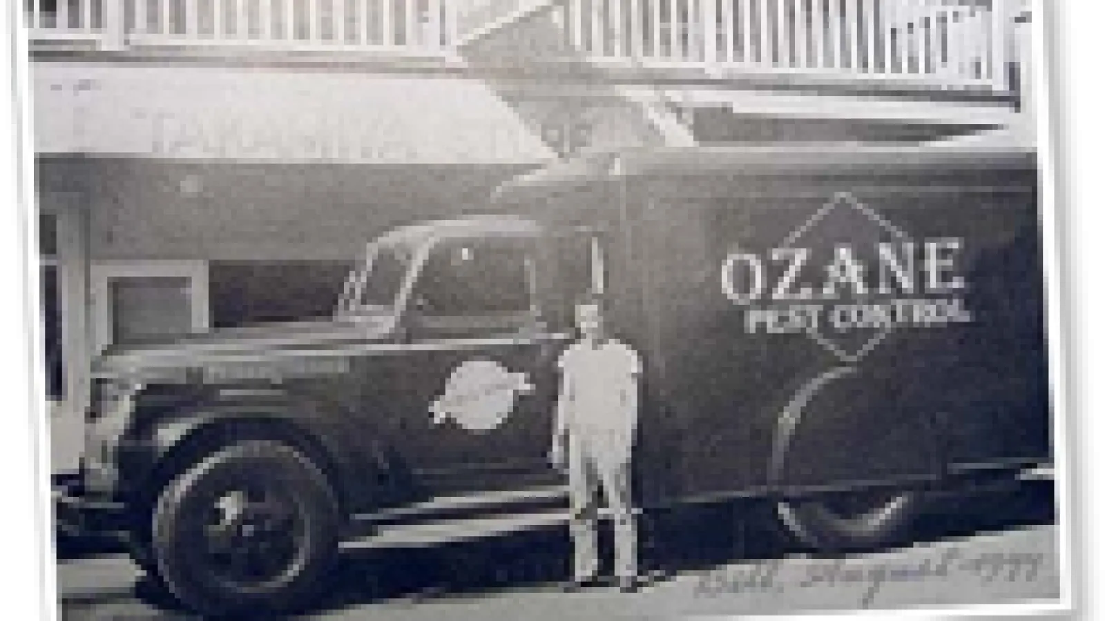 an Ozane team member standing next to a truck in early 1900s