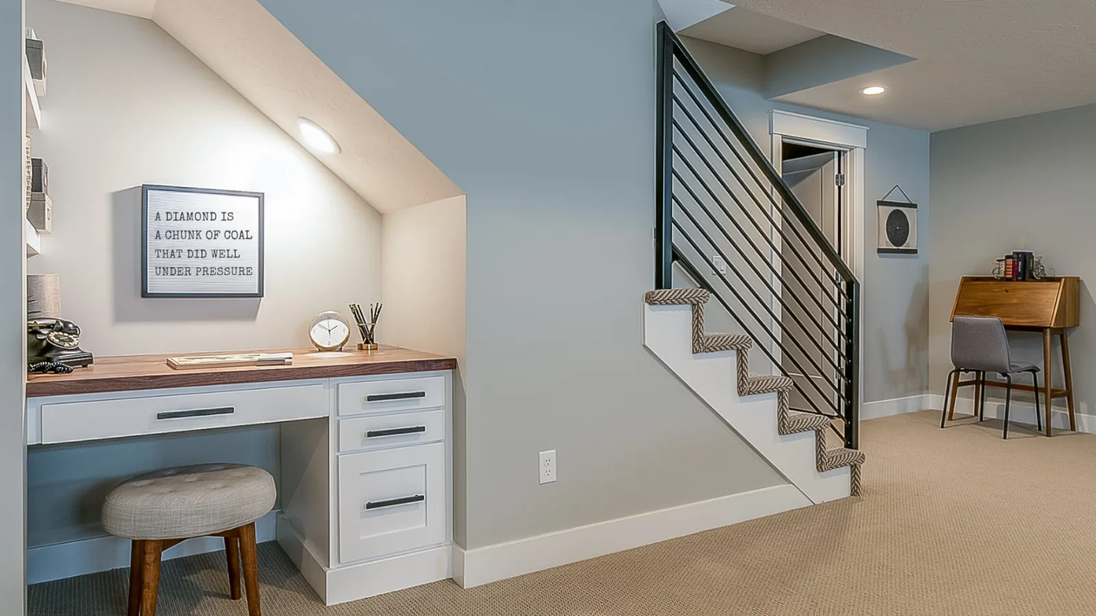 a room with a desk and a staircase