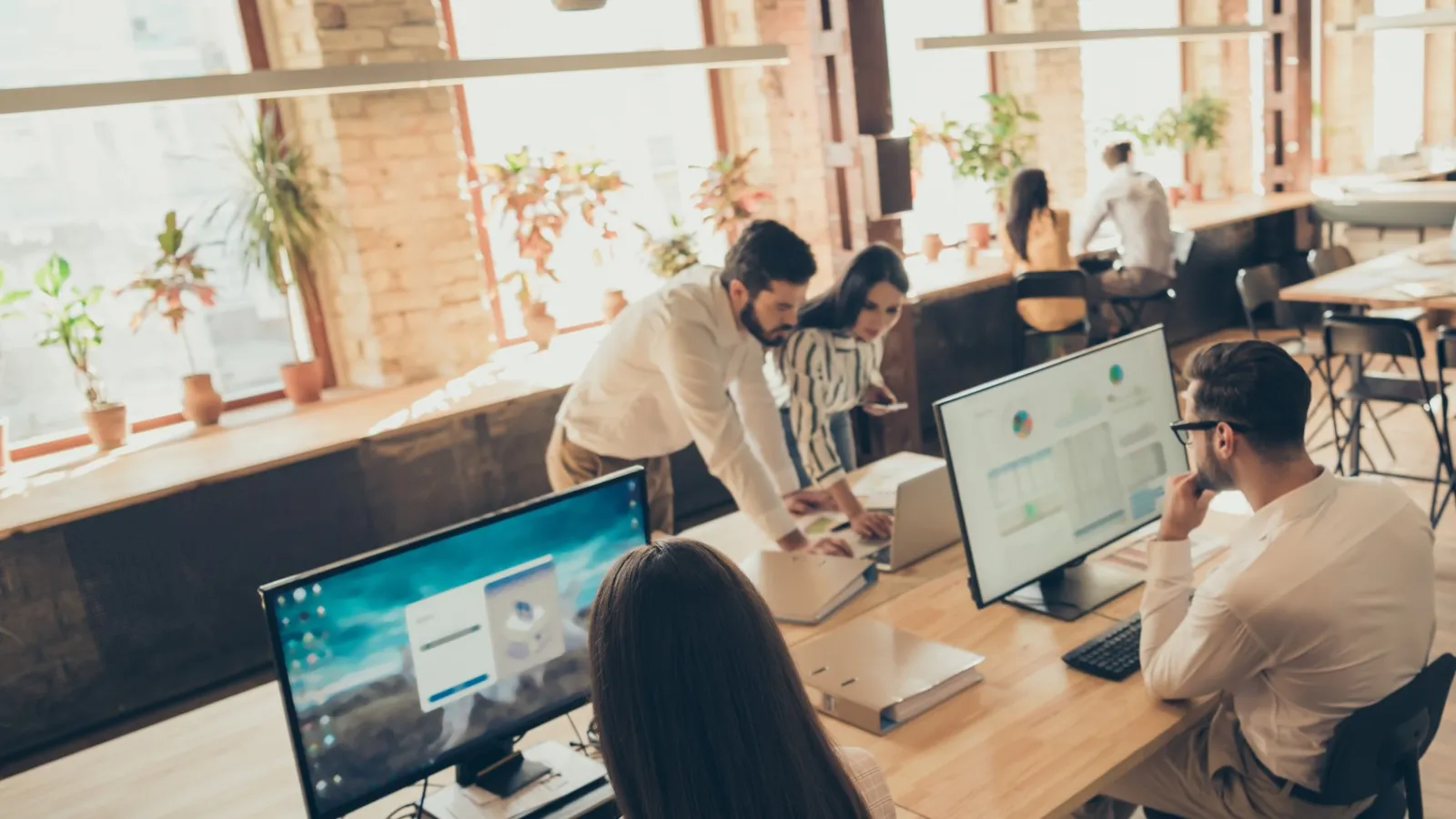 a group of people sitting at a table with computers