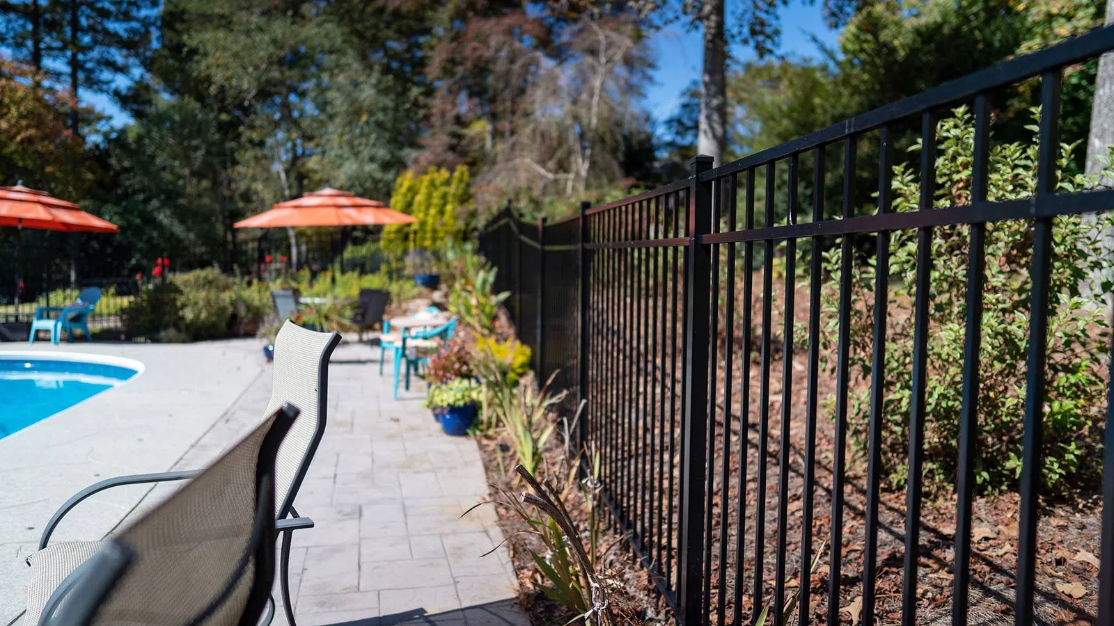 a patio with a fence and a pool