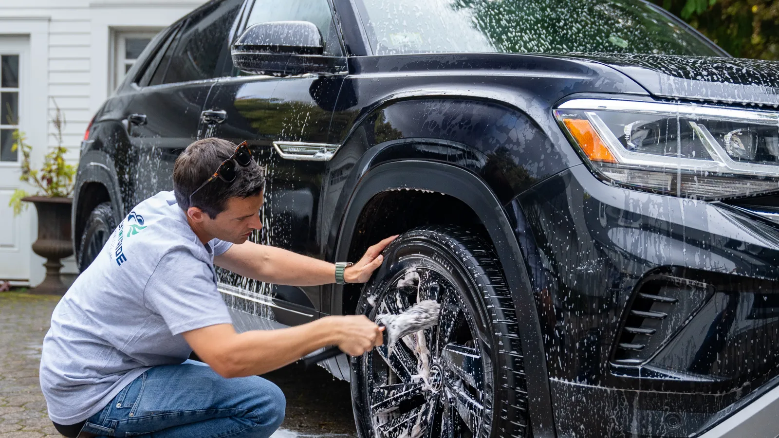 Happy family of three enjoying a car ride, smiling and dancing with seatbelts fastened inside the vehicle.