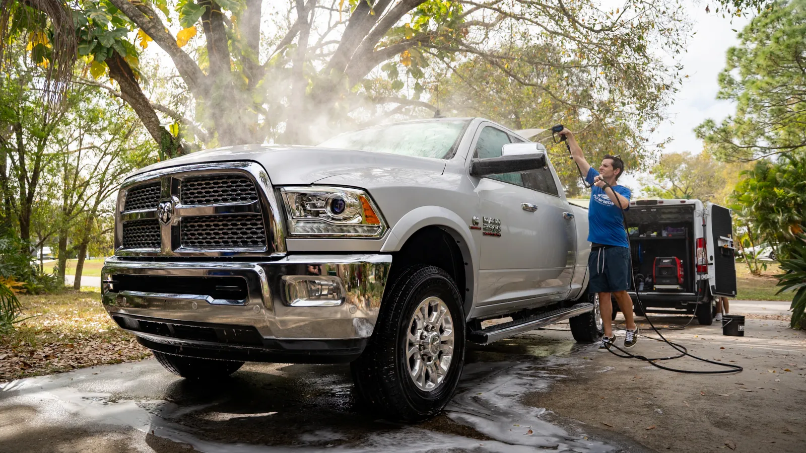 Confident delivery man in white shirt standing with arms crossed by a white cargo van outdoors