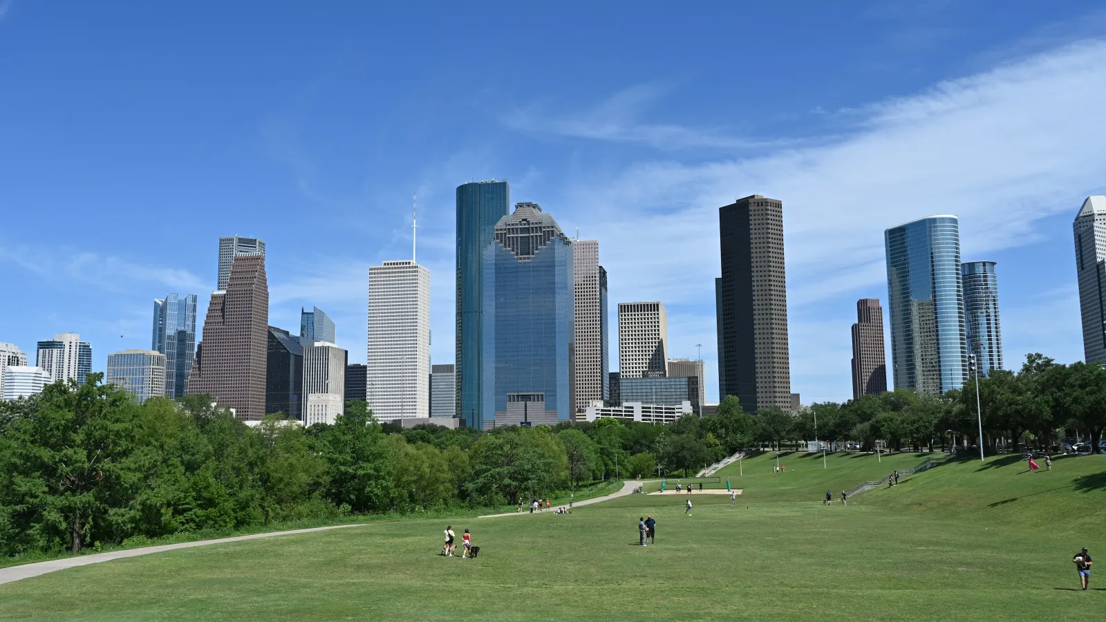 Houston skyline view with green park foreground under bright blue sky on a sunny day