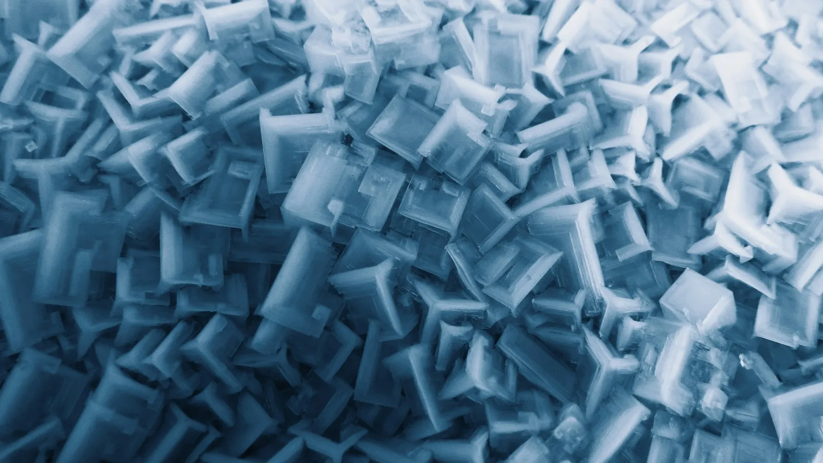 Close-up view of numerous small, blue translucent plastic components densely packed together.