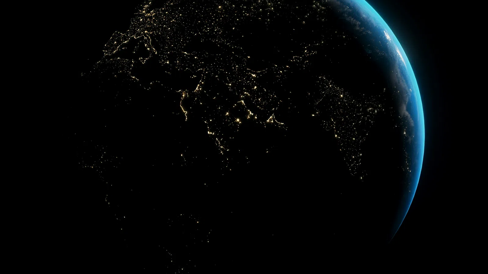 View of Earth at night showing illuminated cities and blue atmospheric glow on the horizon.