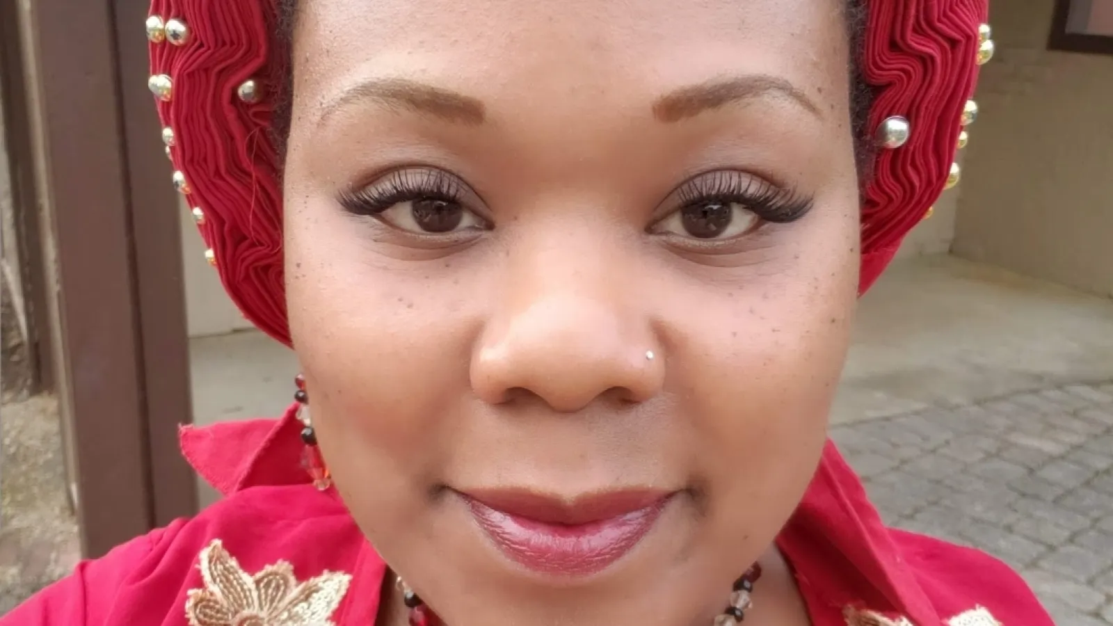 a person wearing a red dress and a red headdress