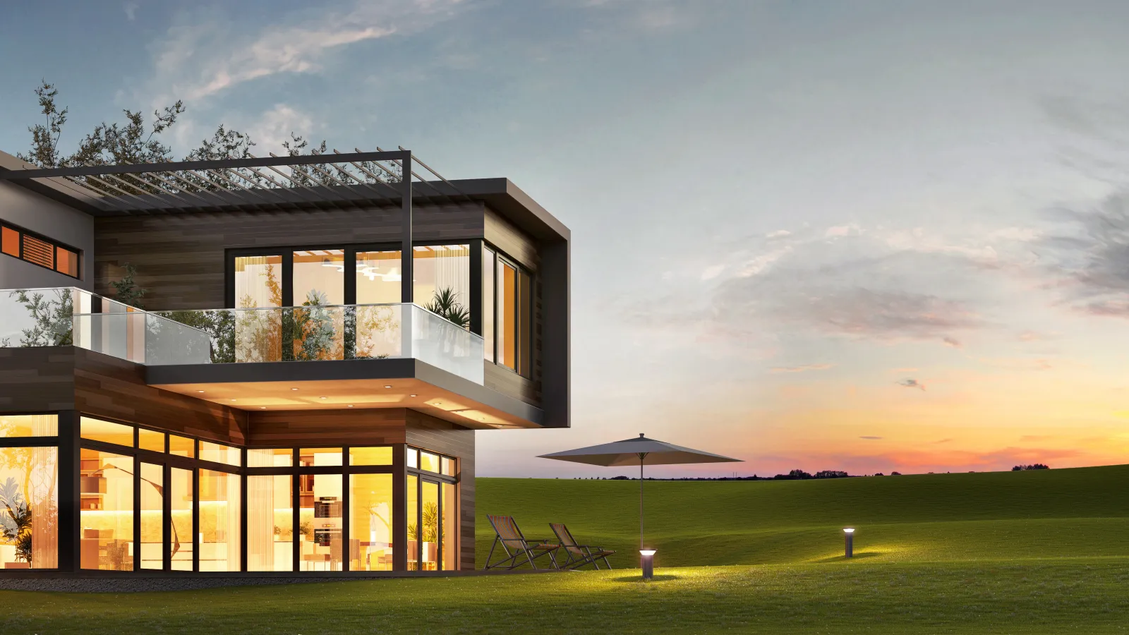 Modern house exterior design at sunset with glass walls and landscaped yard.