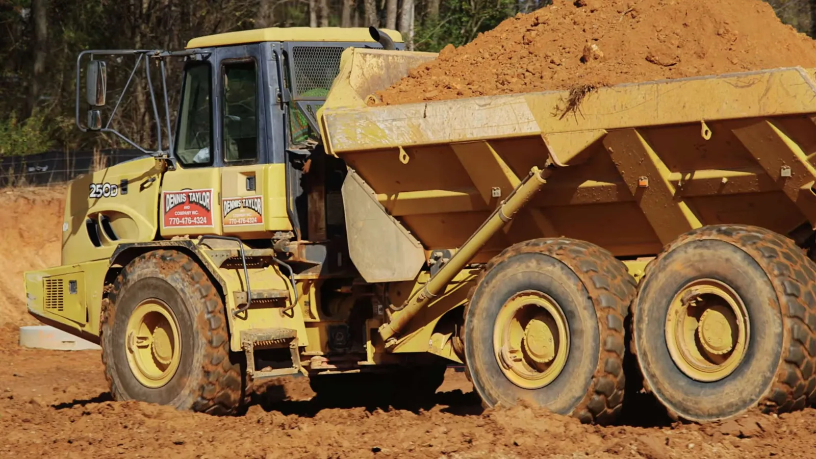 Workers in safety gear install large glass panels with city skyline and Ferris wheel reflections on a sunny day.