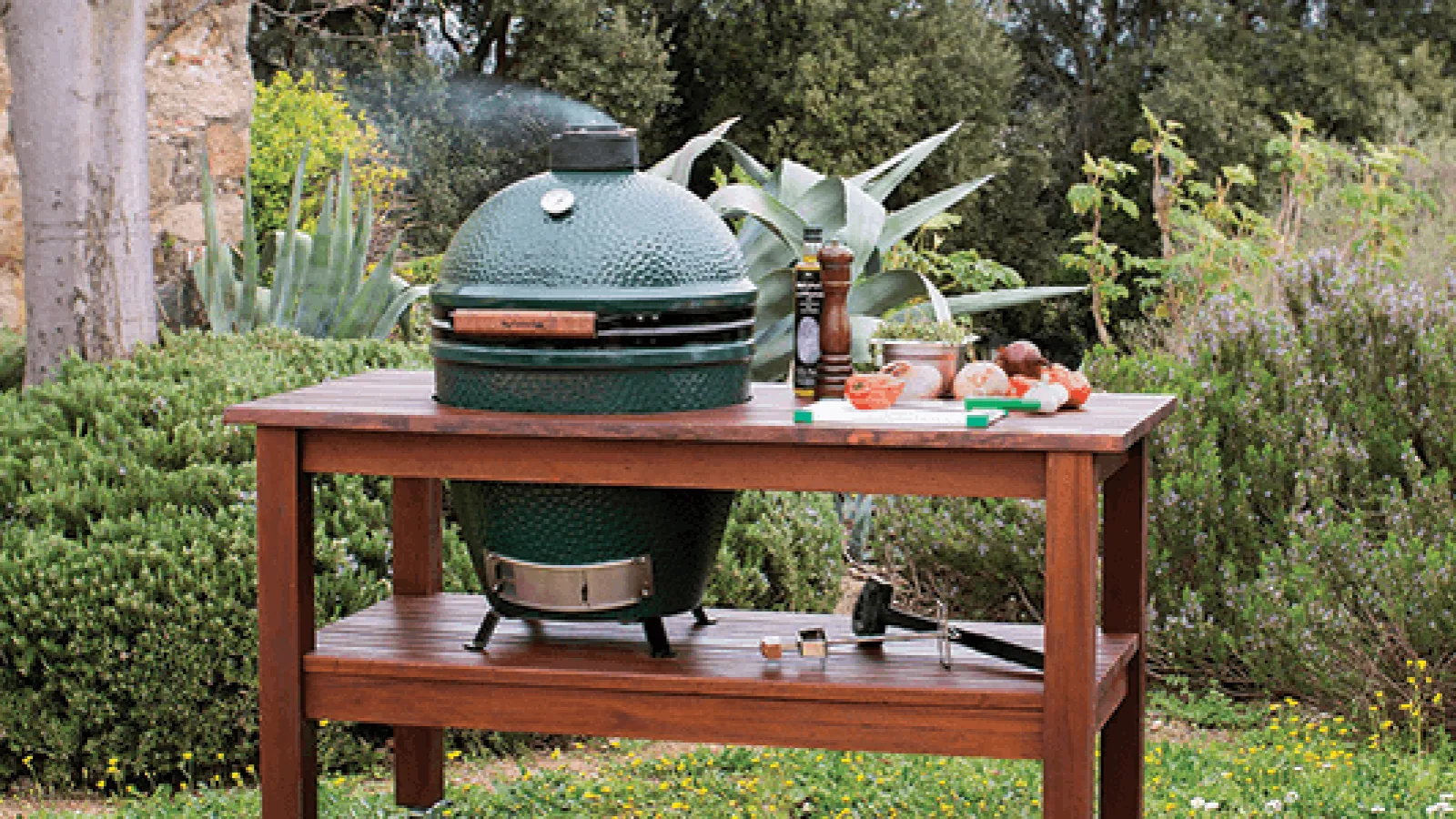a table with a big green egg grill
