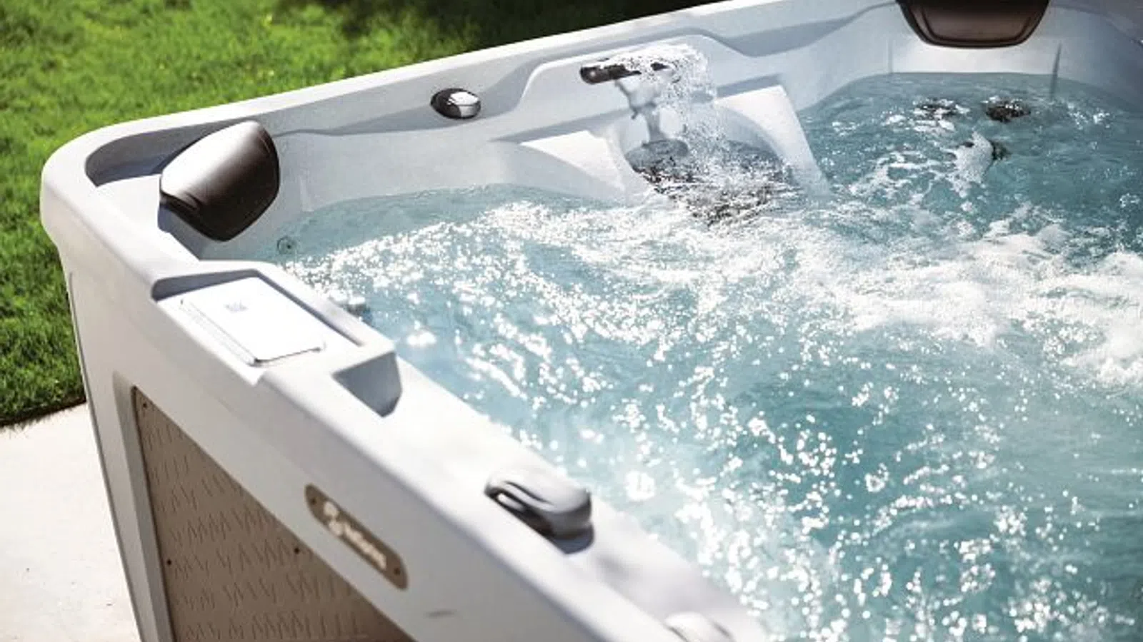 Hot Spring FreeFlow hot tub with clear, bubbling water on a backyard patio