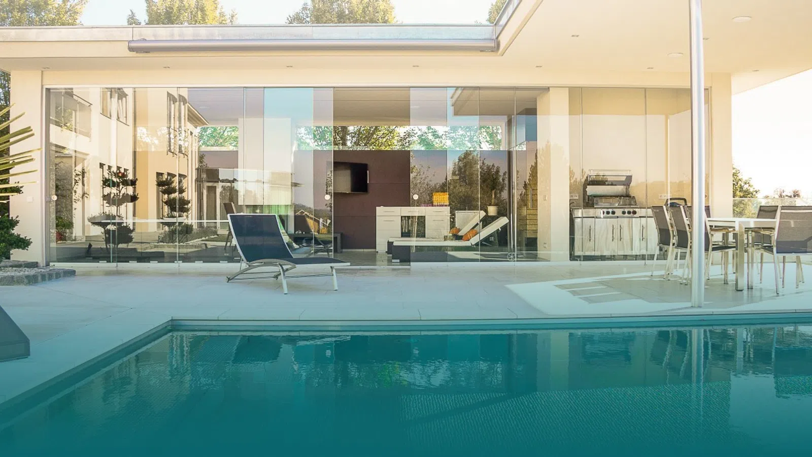 a swimming pool with chairs and a building in the background