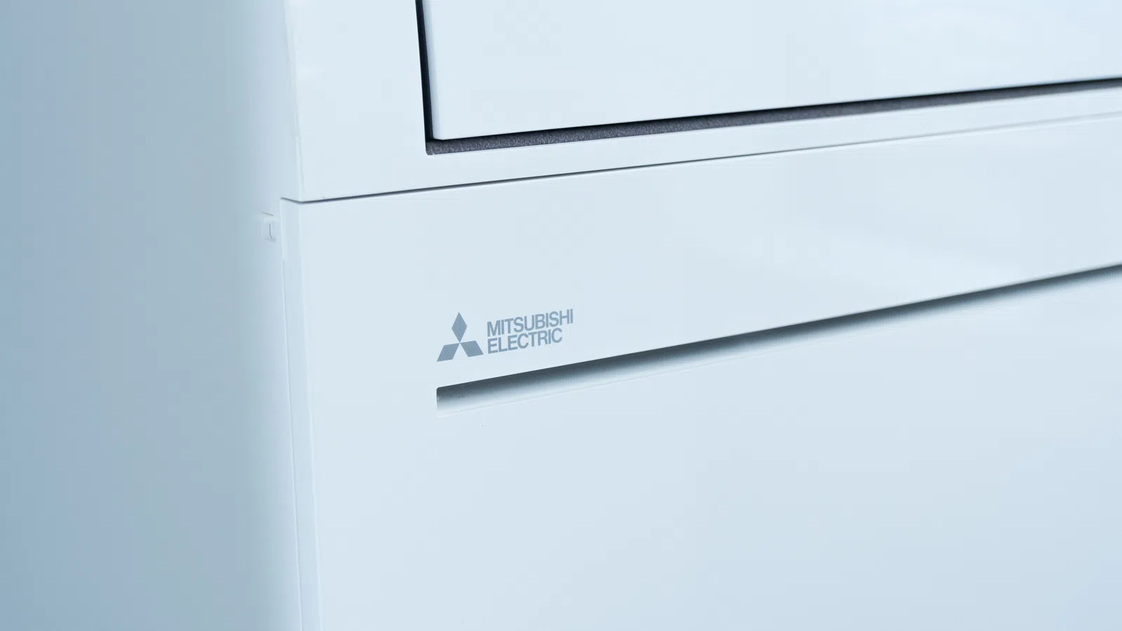 Close-up of a white Mitsubishi Electric air conditioner unit with logo visible on front panel