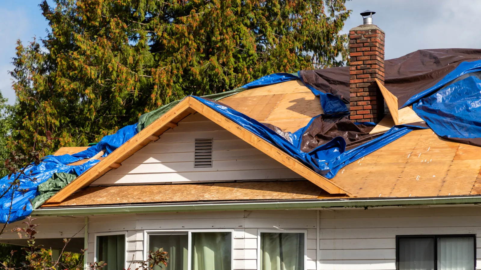 a house that has a blue tarp over it